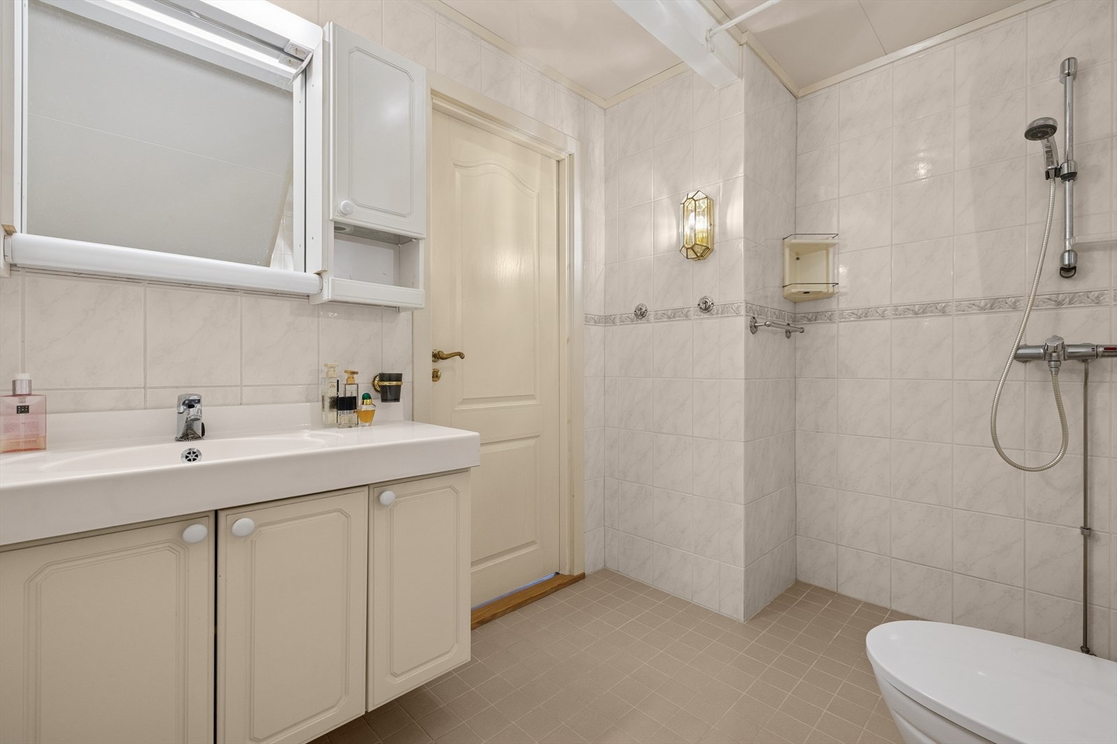 Boligen har til sammen 2 bad - et i hver etasje. Badet i 1. etg. er innredet med slette, lyse fronter og speil med integrert belysning. Galleribilde