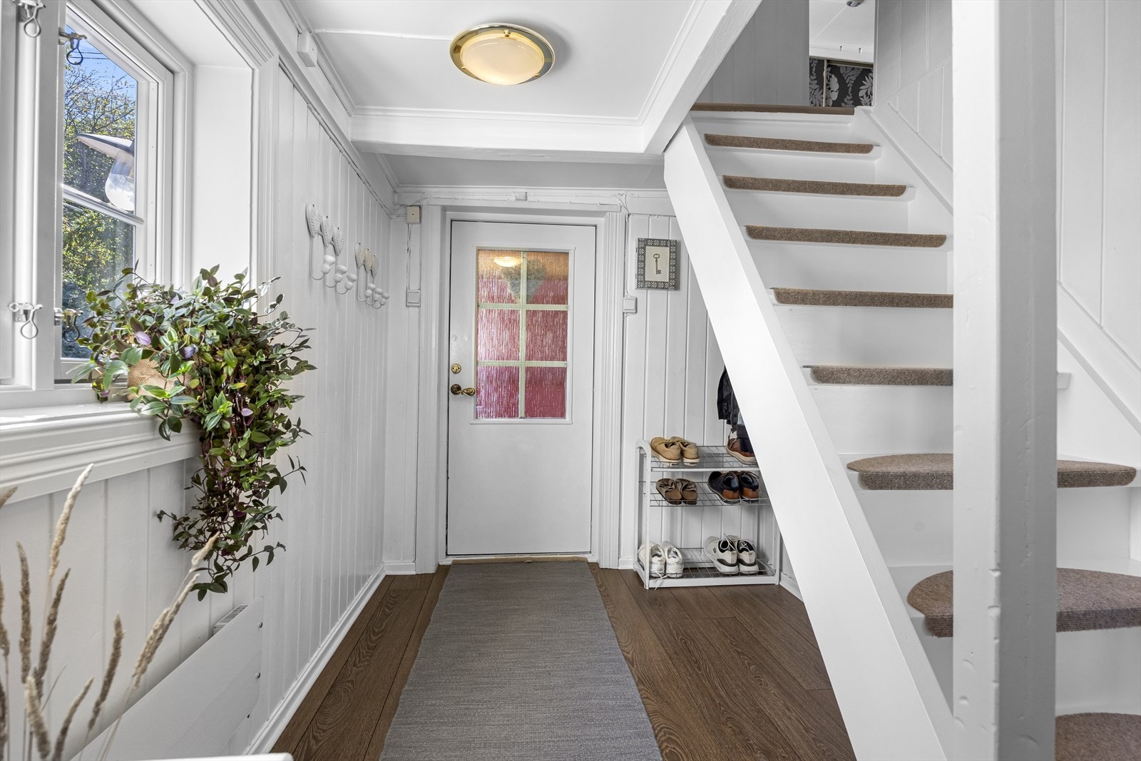 Velkommen inn! Lys gang med plass til jakker og sko under trappen. Galleribilde