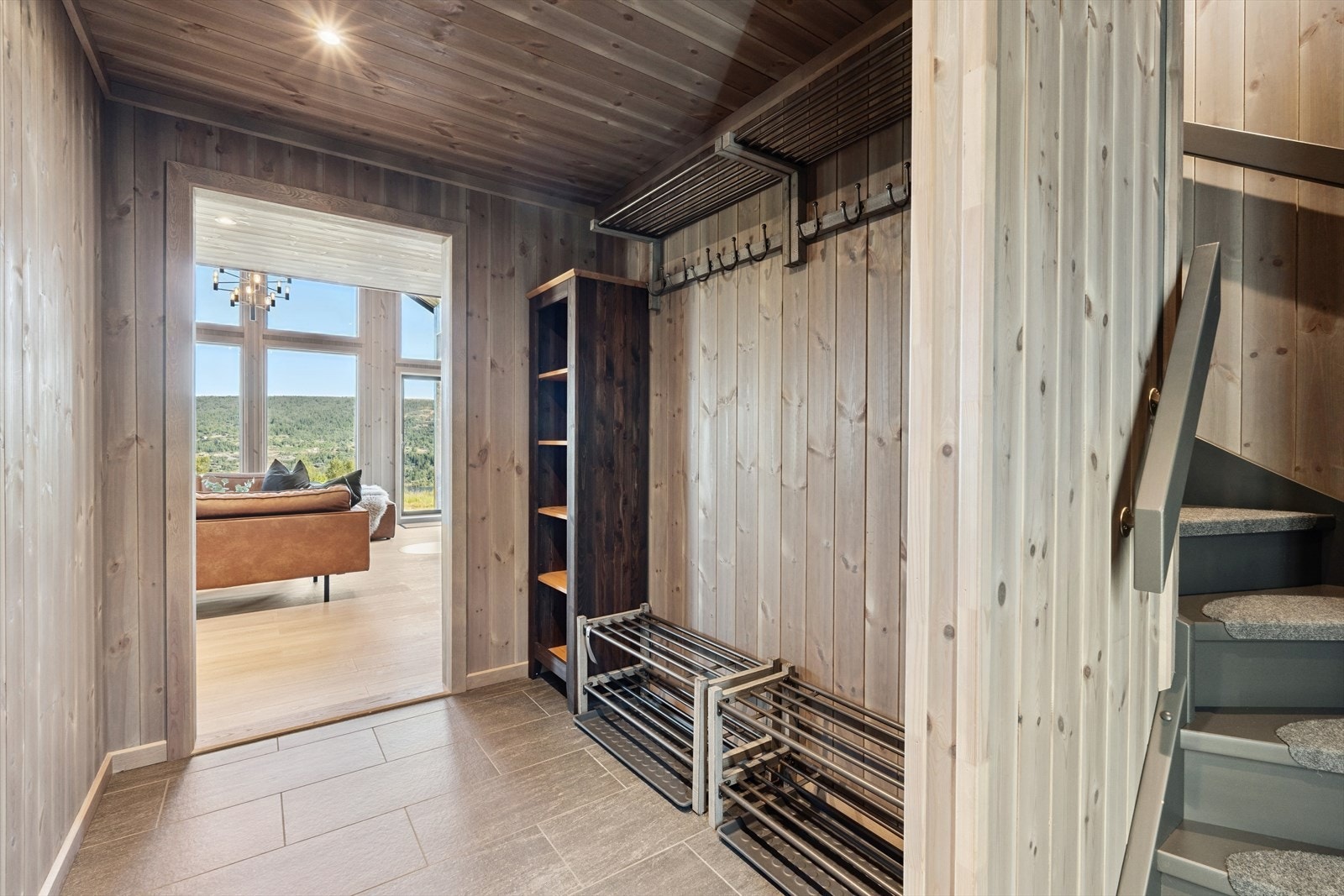 Velkommen inn! Romslig og lun entré med garderobeløsning til oppheng av klær og hyller til sko. Flislagt gulv med varmekabler. Galleribilde