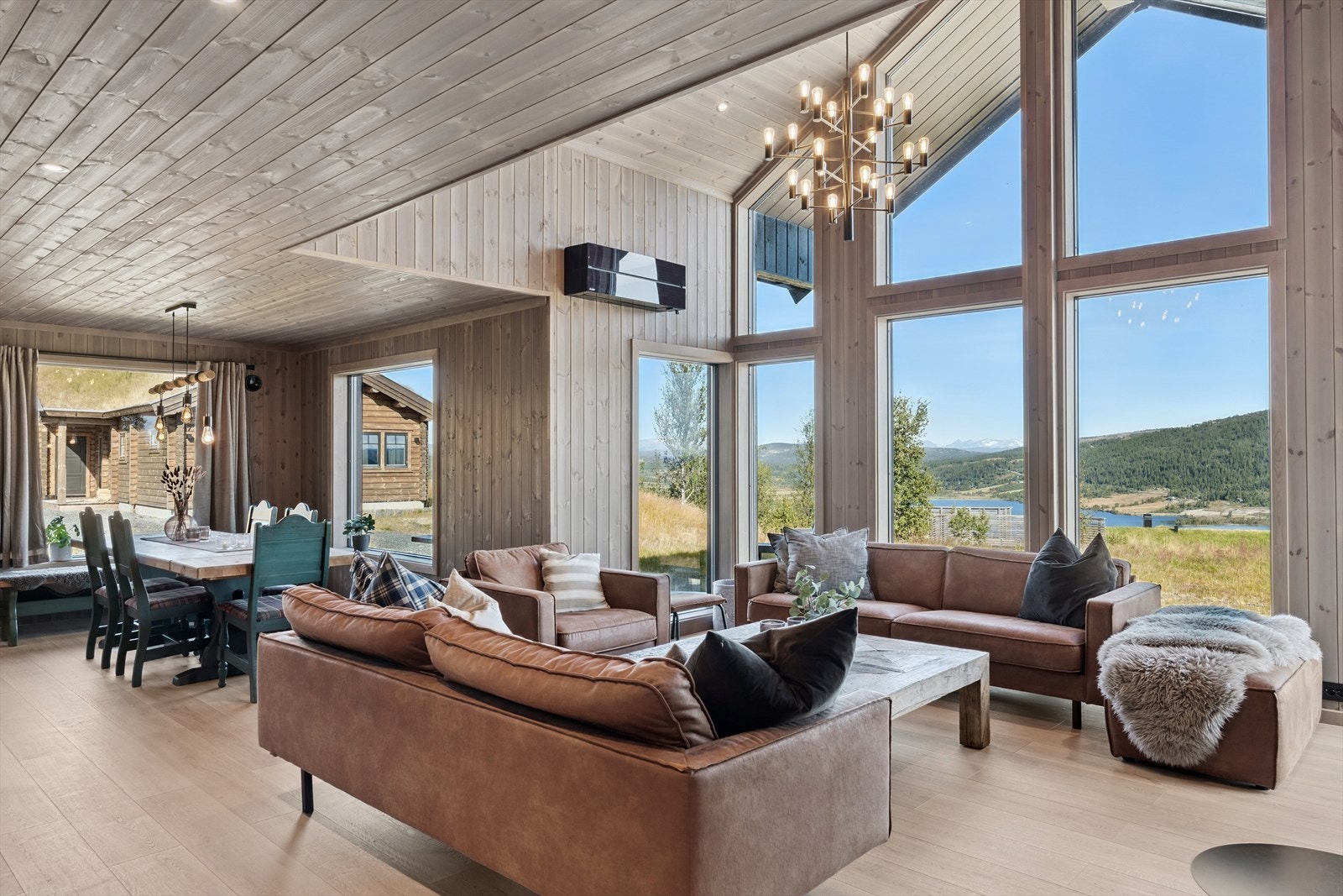 Det høye taket, sammen med de store vindusflatene gjør at stuen oppleves som lys og luftig, og virkelig slipper den flotte utsikten inn. Galleribilde