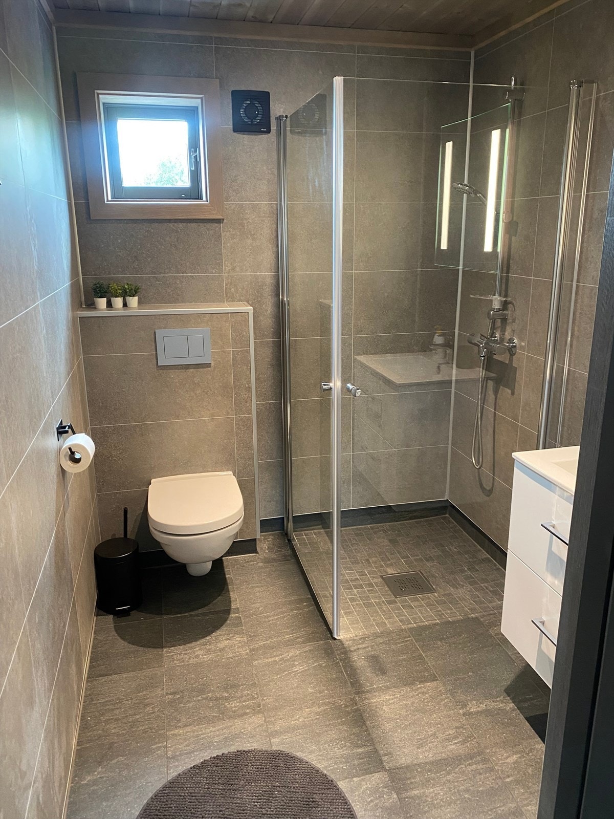 Bad 1 med dusjhjørne, toalett og servant med underskap. Galleribilde