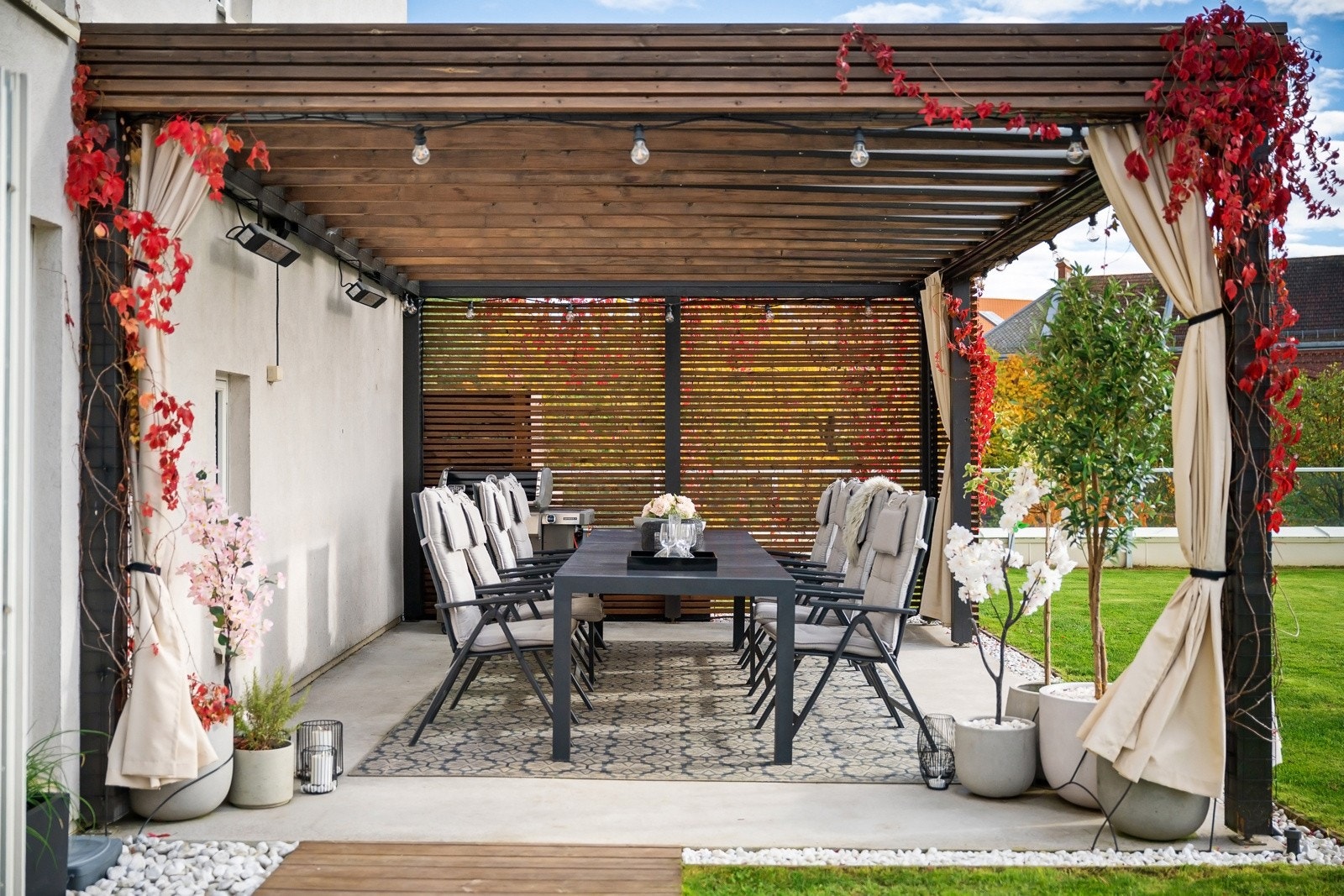 Pergola med god plass stort langbord, opparbeidet med levegg og tak som skjermer mot vær og vind - Varmelamper etablert på vegg forlenger bruksperioden. Galleribilde