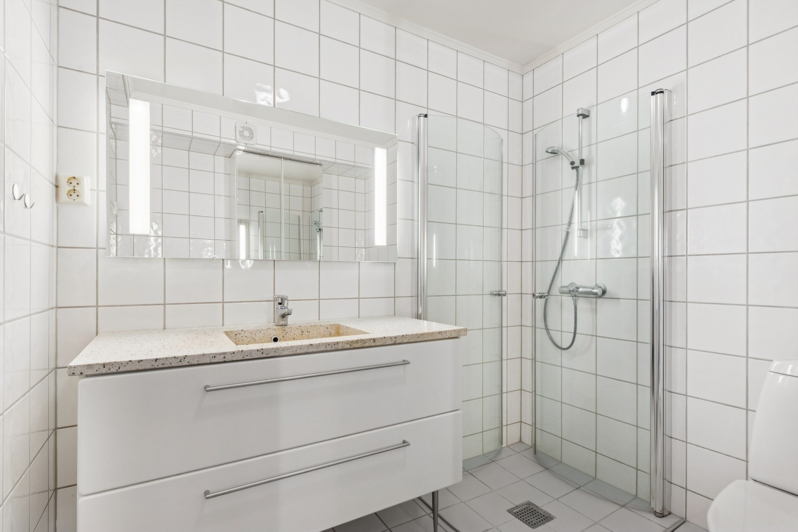 Pen baderomsinnredning med romslige skuffer og heldekkende benkeplate med nedfelt servant. Galleribilde