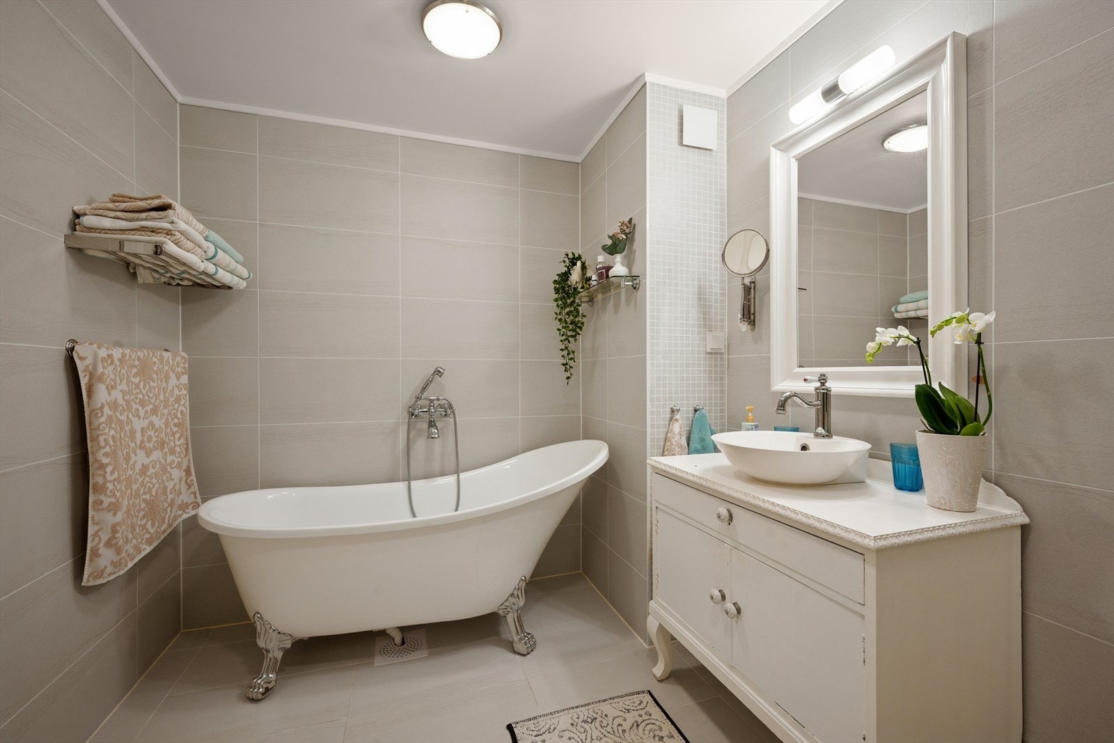 Rommet er innredet med nedfelt servant, vegghengt toalett, dusj og badekar. Galleribilde