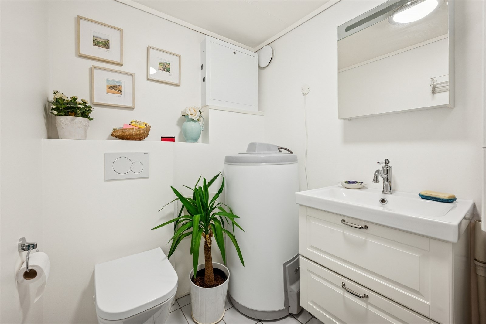 Innredet med nedfelt servant, veggmontert toalett, opplegg for vaskemaskin og speilskap. Galleribilde