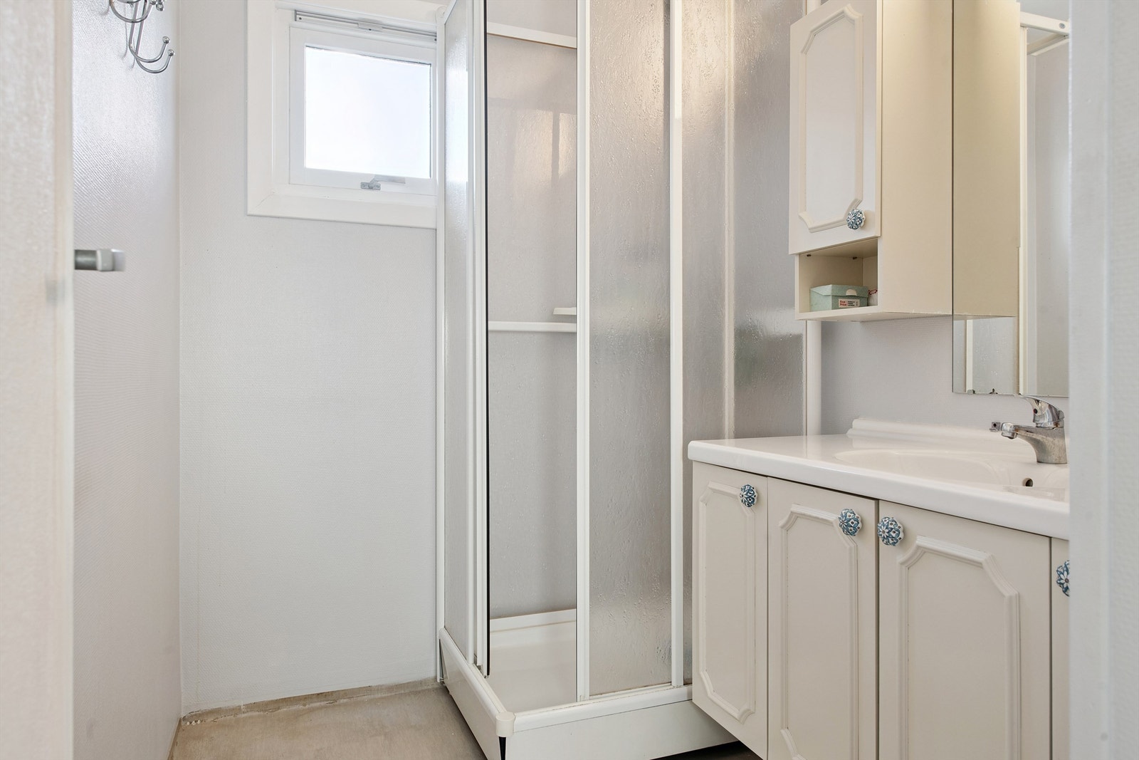 Badet er utstyrt med servantinnredning, speil, skap og et praktisk dusjkabinett. Galleribilde