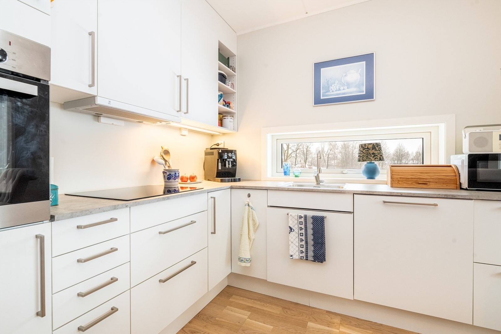 Lys, takhøy innredning med tidløse fronter og laminat benkeplate. Galleribilde