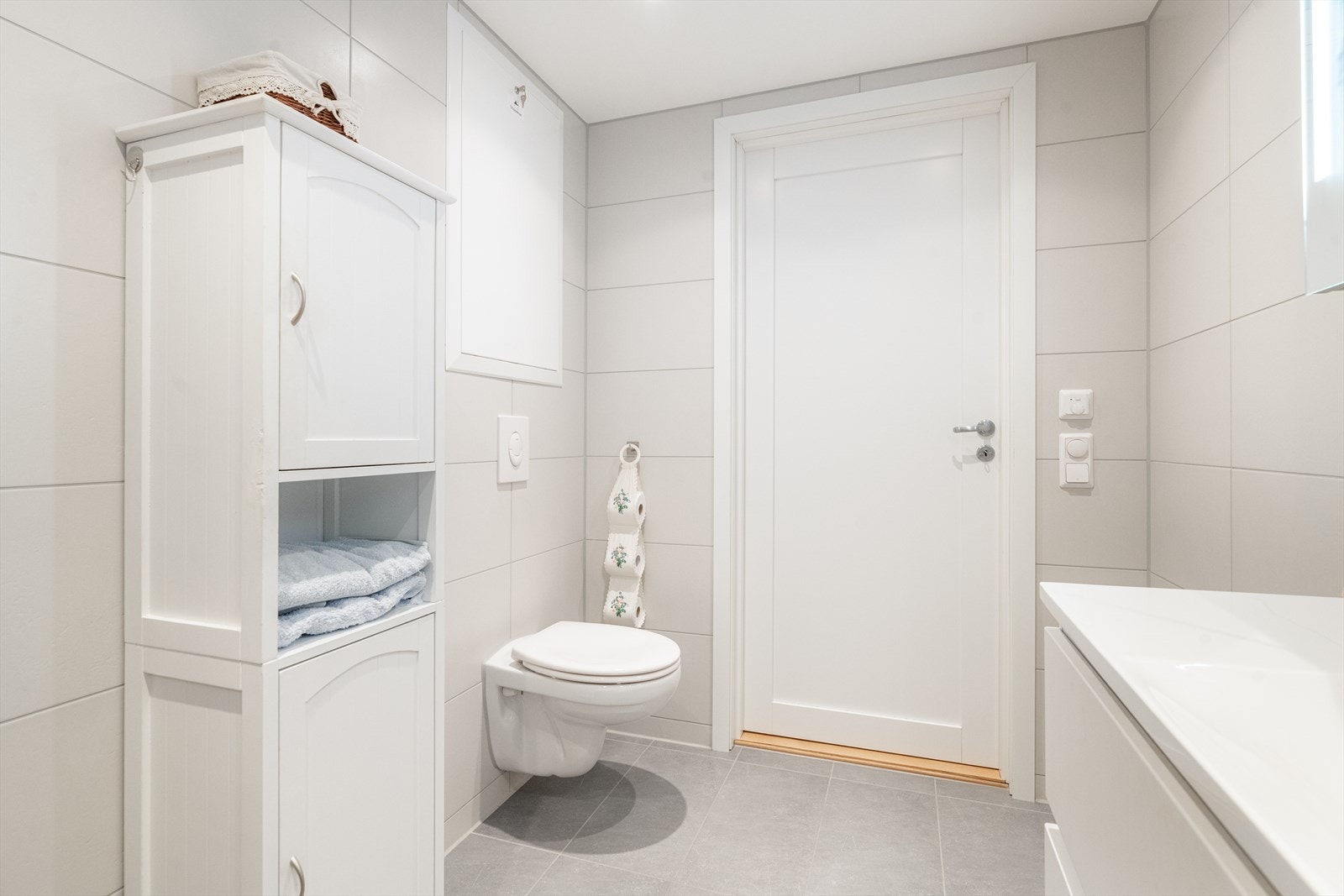 Badet er også utstyrt med gulvvarme, vegghengt toalett og åpen dusj med glassdører, samt opplegg for vaskemaskin. Downlights i tak. Galleribilde