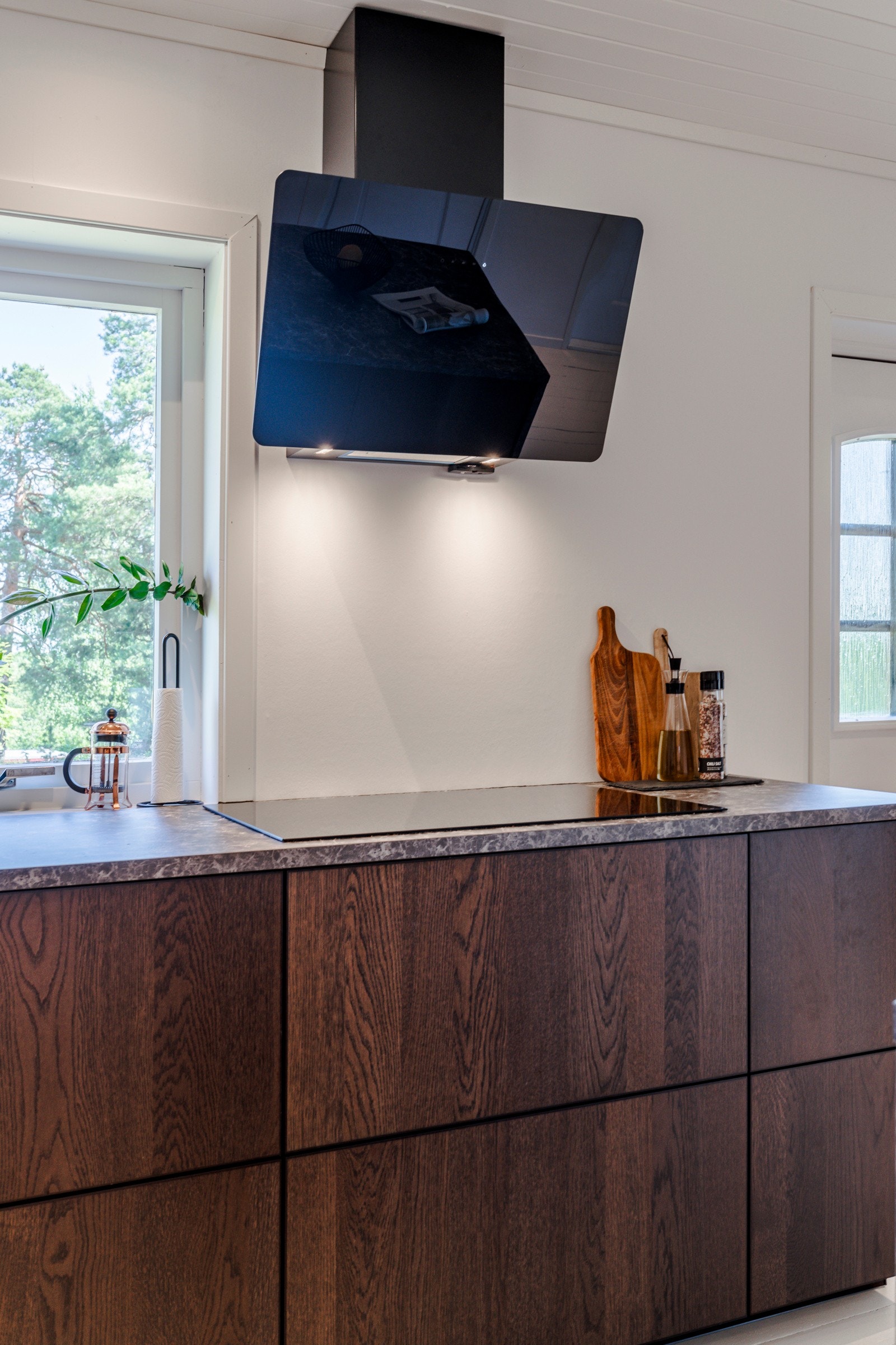 Ventilator med avtrekk over tak er montert på vegg over koketoppen og sørger for effektiv utlufting. Galleribilde