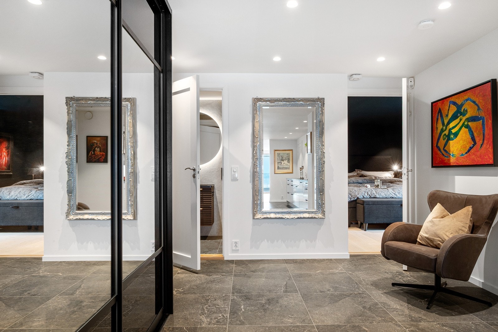 Entreen har moderne fliser, skyvedørsgarderobe med speilfronter og plass til sittebenk eller ønsket oppbevaringsmøbel. Galleribilde