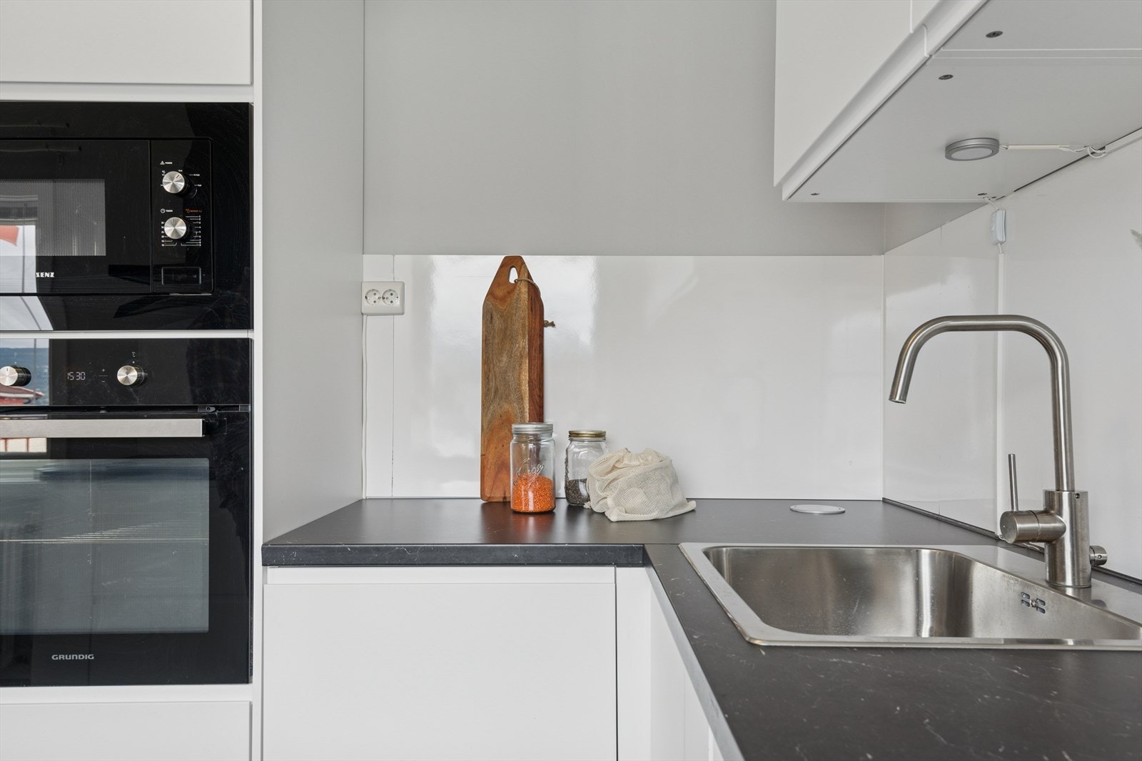 Det er montert lyse laminatplater mellom over- og underskap for enklere rengjøring, samt benkebelysning som gir gode arbeidsforhold. Galleribilde