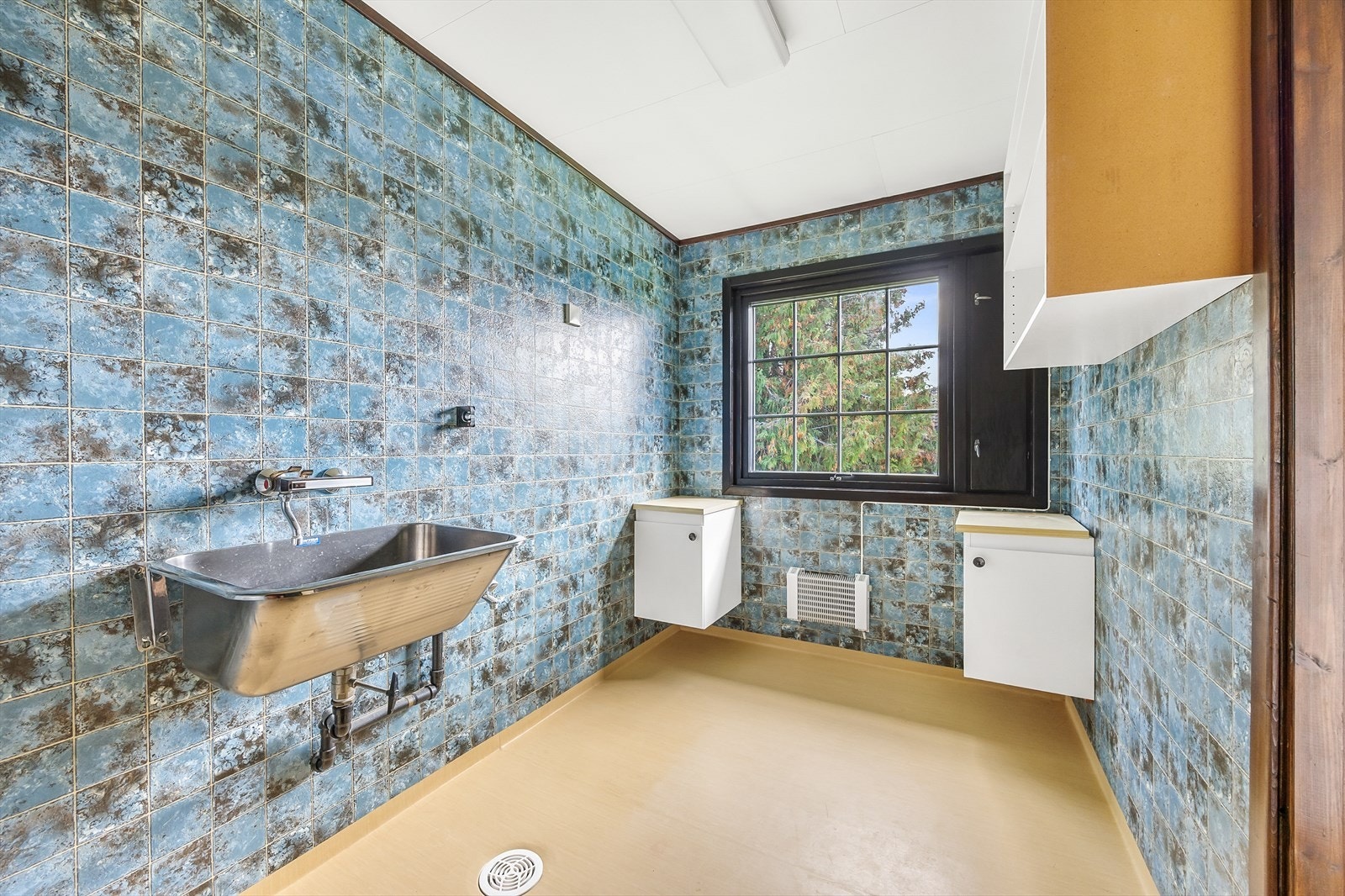 Boligen har også et eget vaskerom av god størrelse. I tillegg til opplegg for vaskemaskin er rommet utstyrt med skyllekum og veggskap. Galleribilde