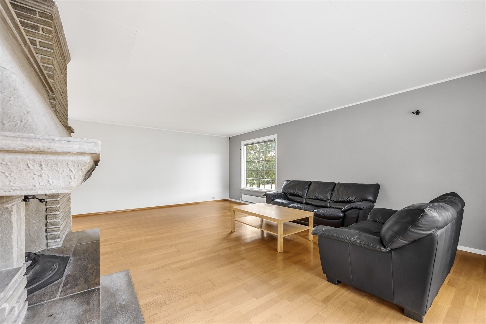 Det er god plass til flere sittegrupper og tv/medialøsning. På gulvet er det parkett, mens veggene er i en kombinasjon av hvitt og grått. Galleribilde