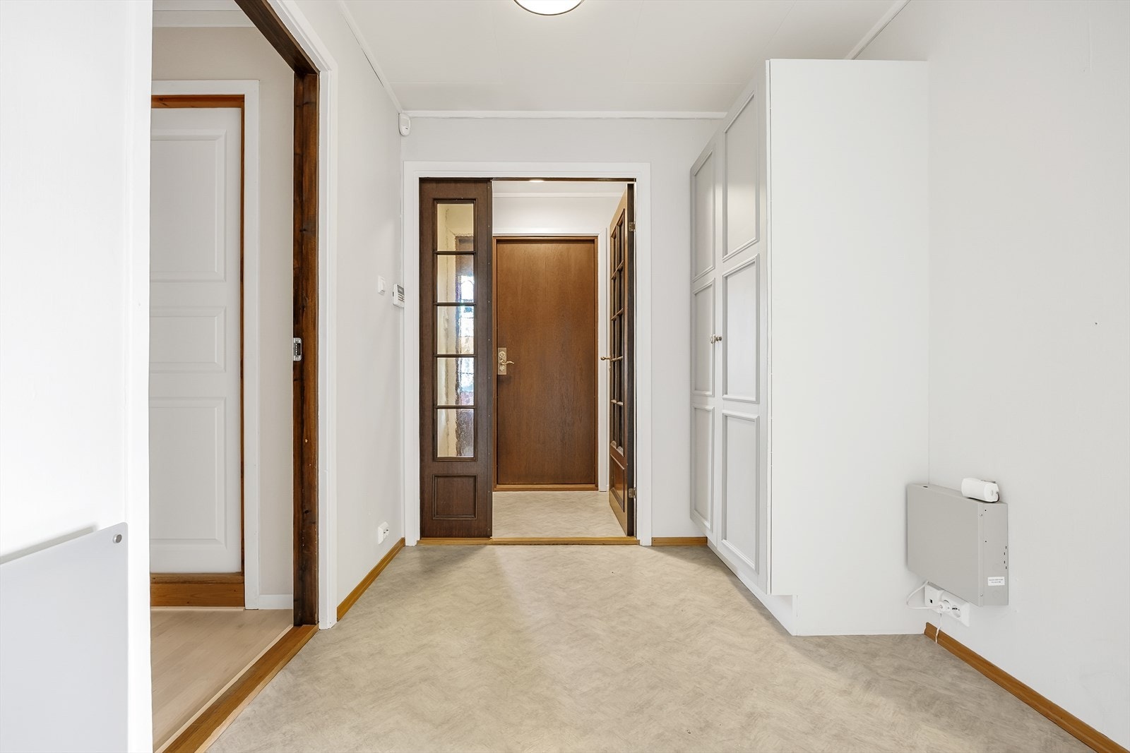 Videre inn ligger en romslig gang med garderobeskap for praktisk oppbevaring av ytterklær og sko. Galleribilde