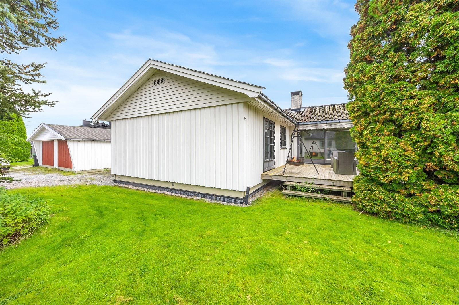 Tomten er på 890 kvm og pent opparbeiet med plenarealer, prydbusker og høye, skjermende trær. Galleribilde