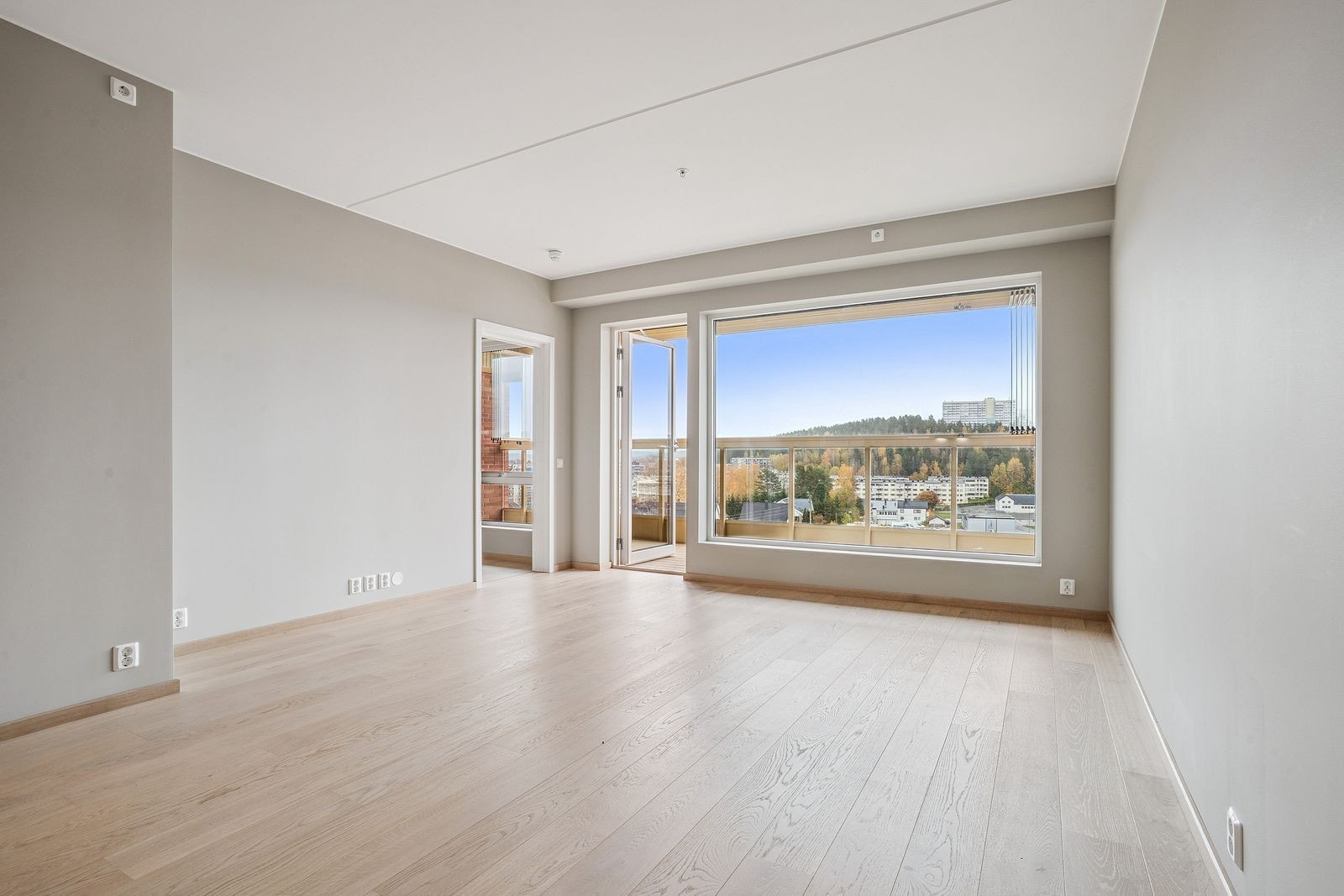 Romslig stue med store vindusflater og utgang til balkongen. Galleribilde