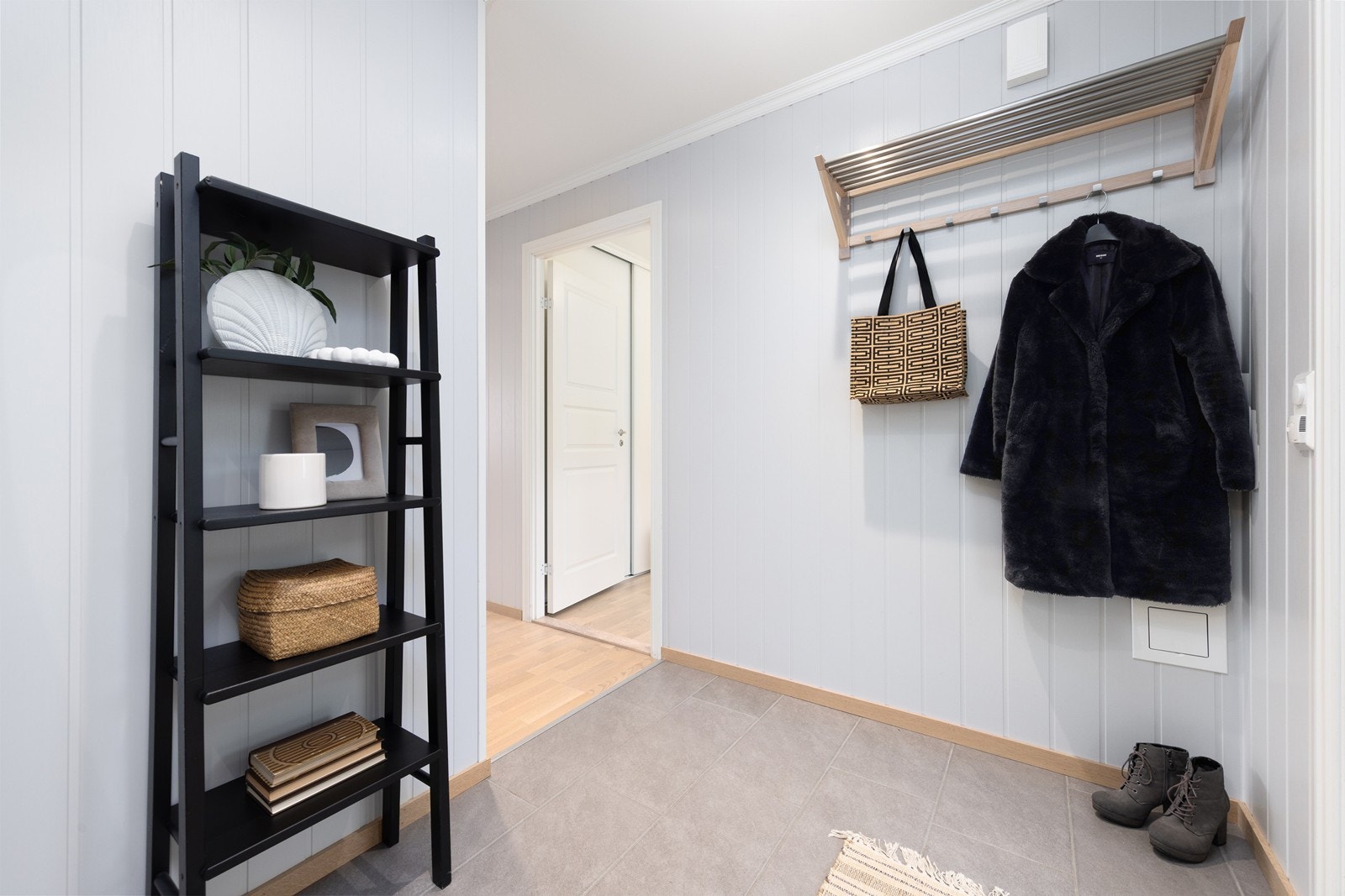 Man ønskes velkommen inn i en romslig og luftig entré med god plass til å henge fra seg yttertøy og oppbevare sko. Galleribilde