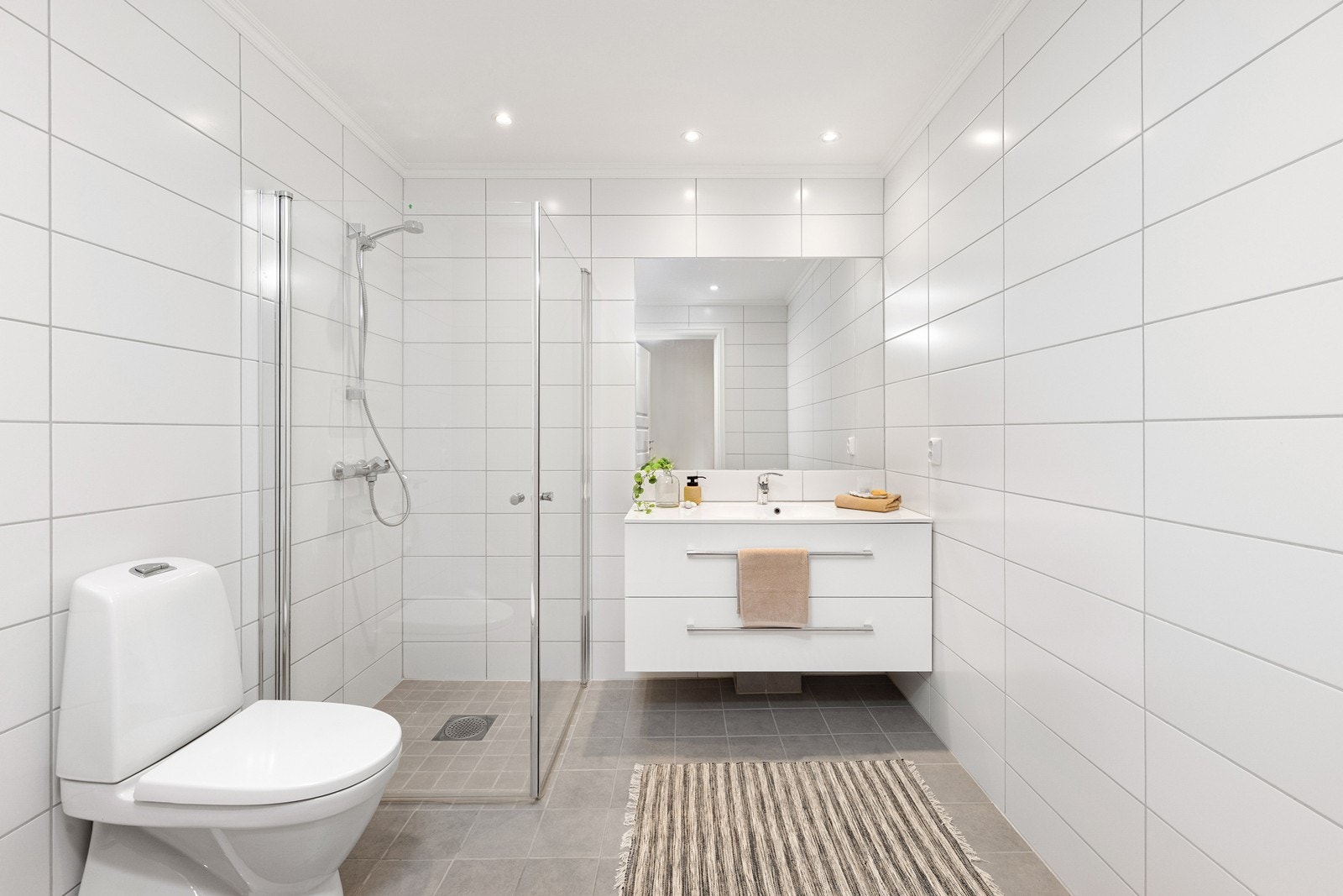 Badet er stilrent og flislagt, med elektrisk gulvvarme og downlights i himlingen. Galleribilde