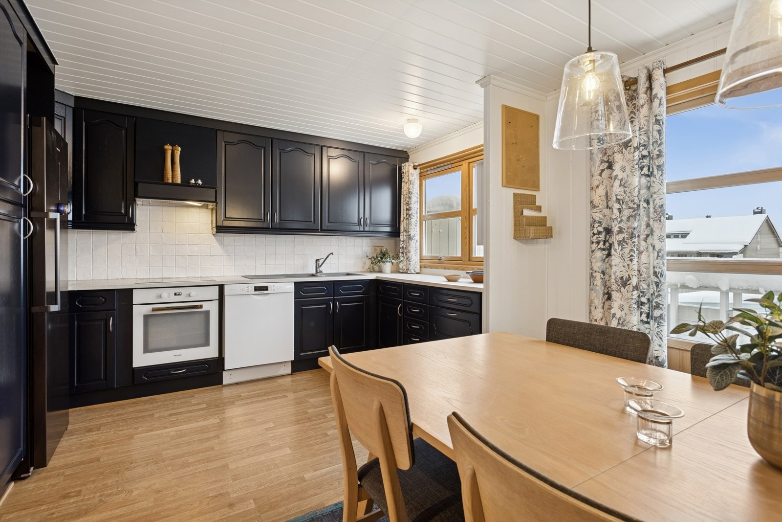 Pent familiekjøkken med profilerte fronter og integrerte hvitevarer. Galleribilde