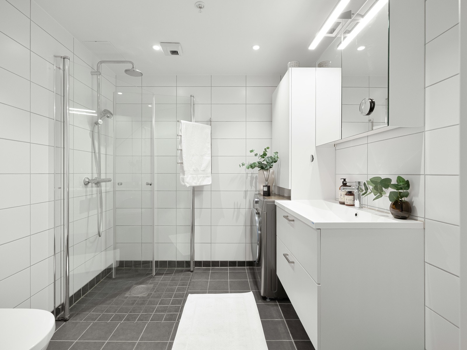 Videre har leiligheten et lyst, flislagt baderom med tidløs innredning. Galleribilde