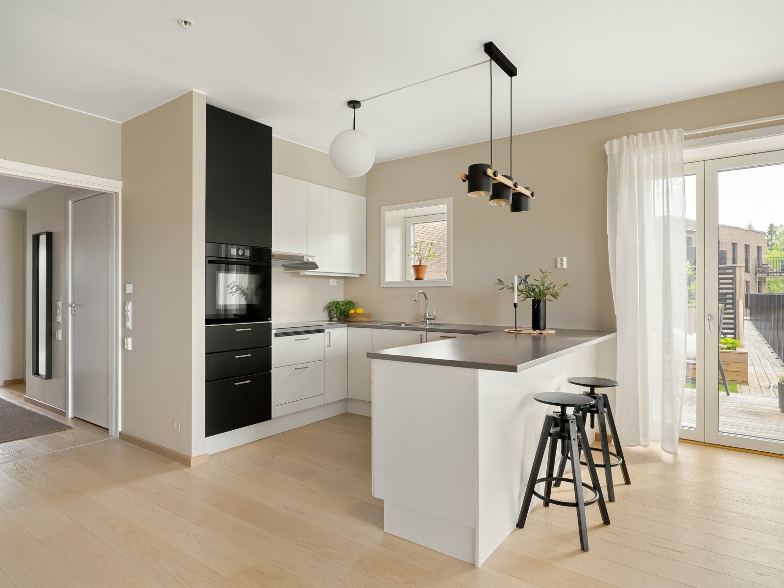 Stilrent kjøkken i åpen løsning. Praktisk kjøkkenhalvøy med spiseplass og ekstra oppbevaring. Galleribilde