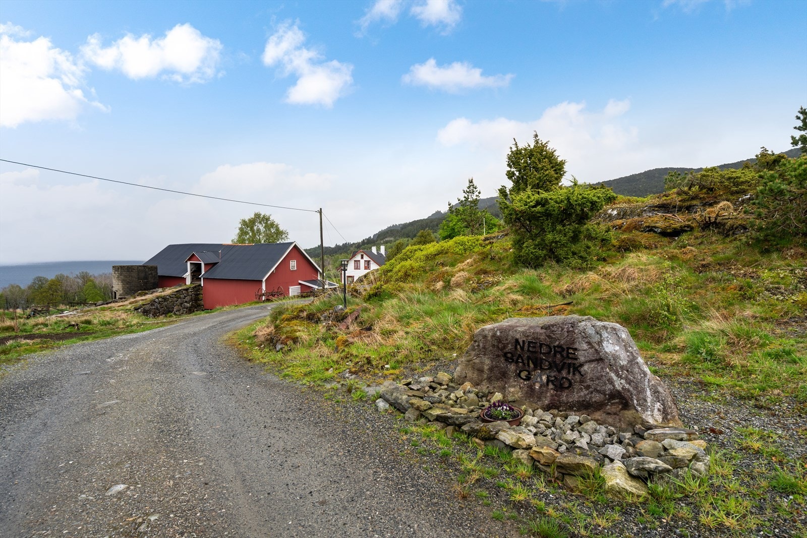 Adkomst inn til eiendommen med løe / lager i bakgrunnen Galleribilde