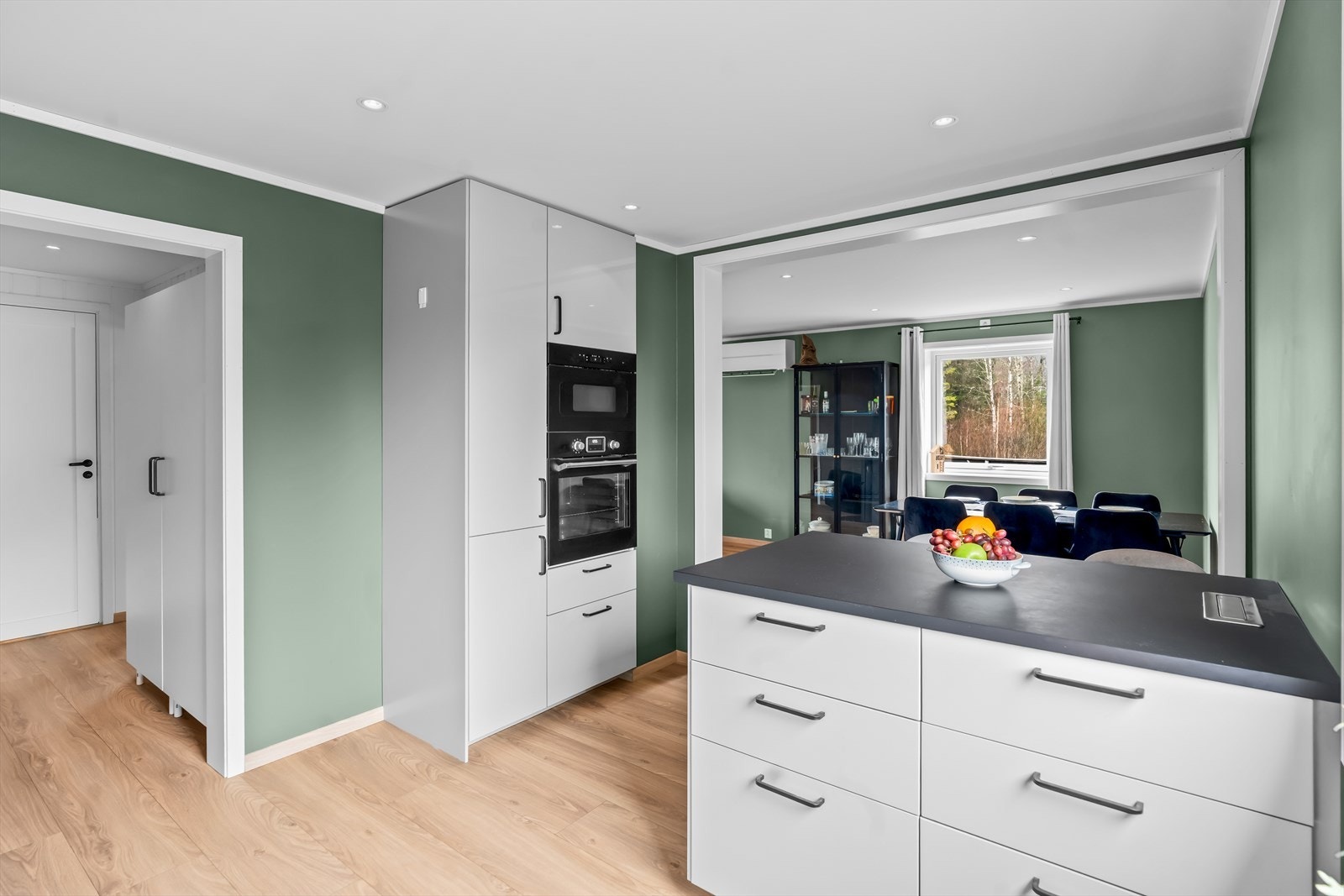 Et funksjonelt og stilrent kjøkken med integrerte hvitevarer, samt rikelig skap- og benkeplass for en sømløs hverdagsflyt. Galleribilde