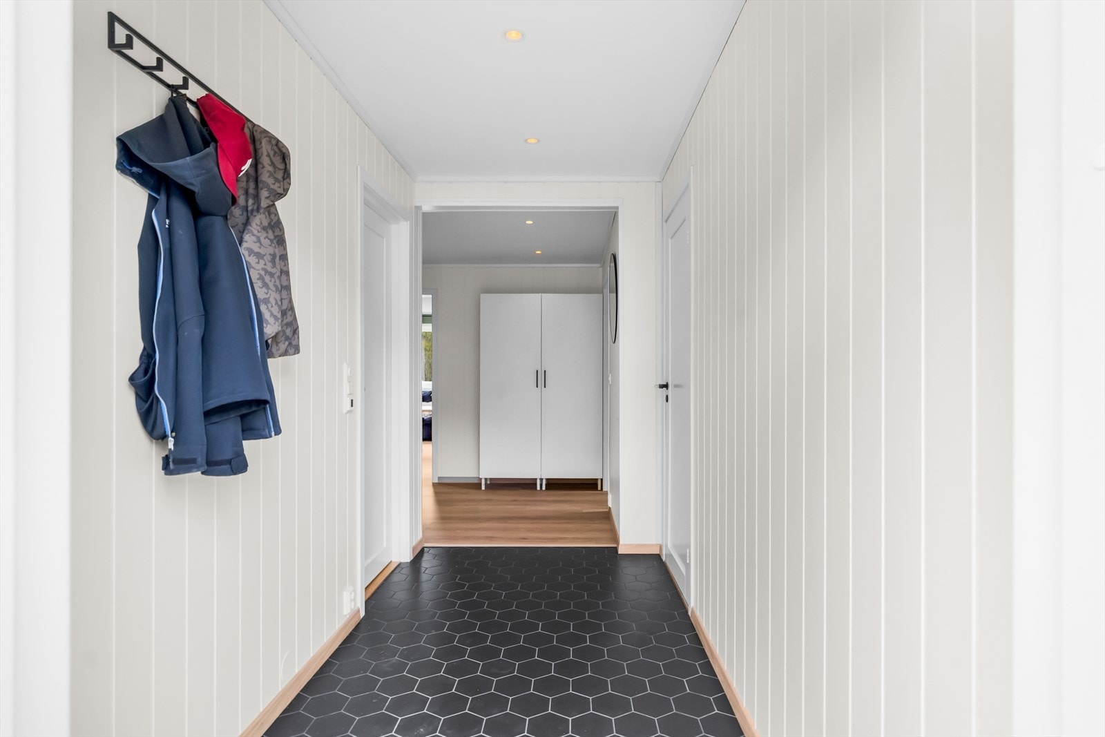 Entréen er lys og romslig, og skaper et innbydende førsteinntrykk av boligen. Galleribilde