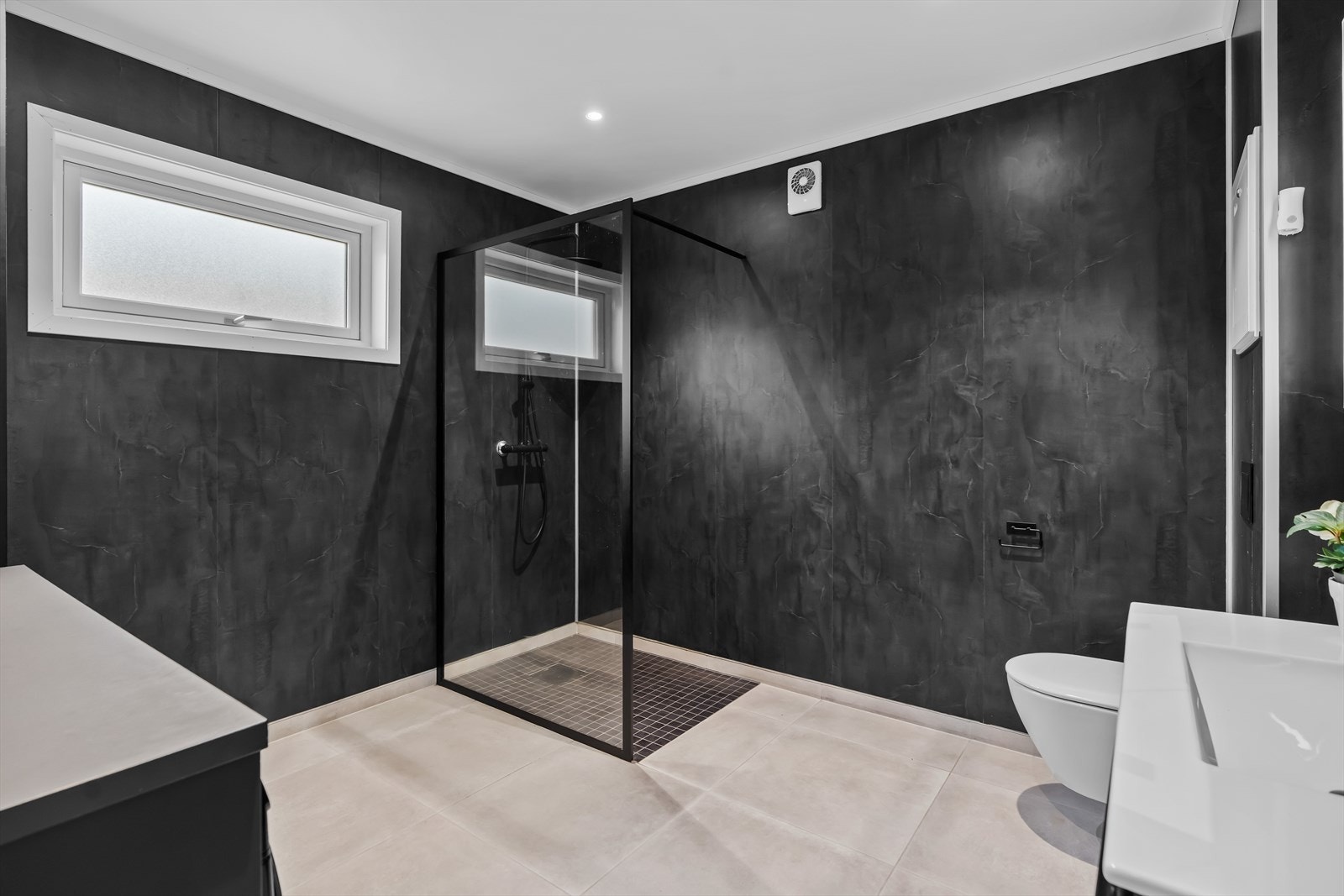 Moderne og delikat bad med fliser på gulv og vegger, gulvvarme og downlights. Galleribilde