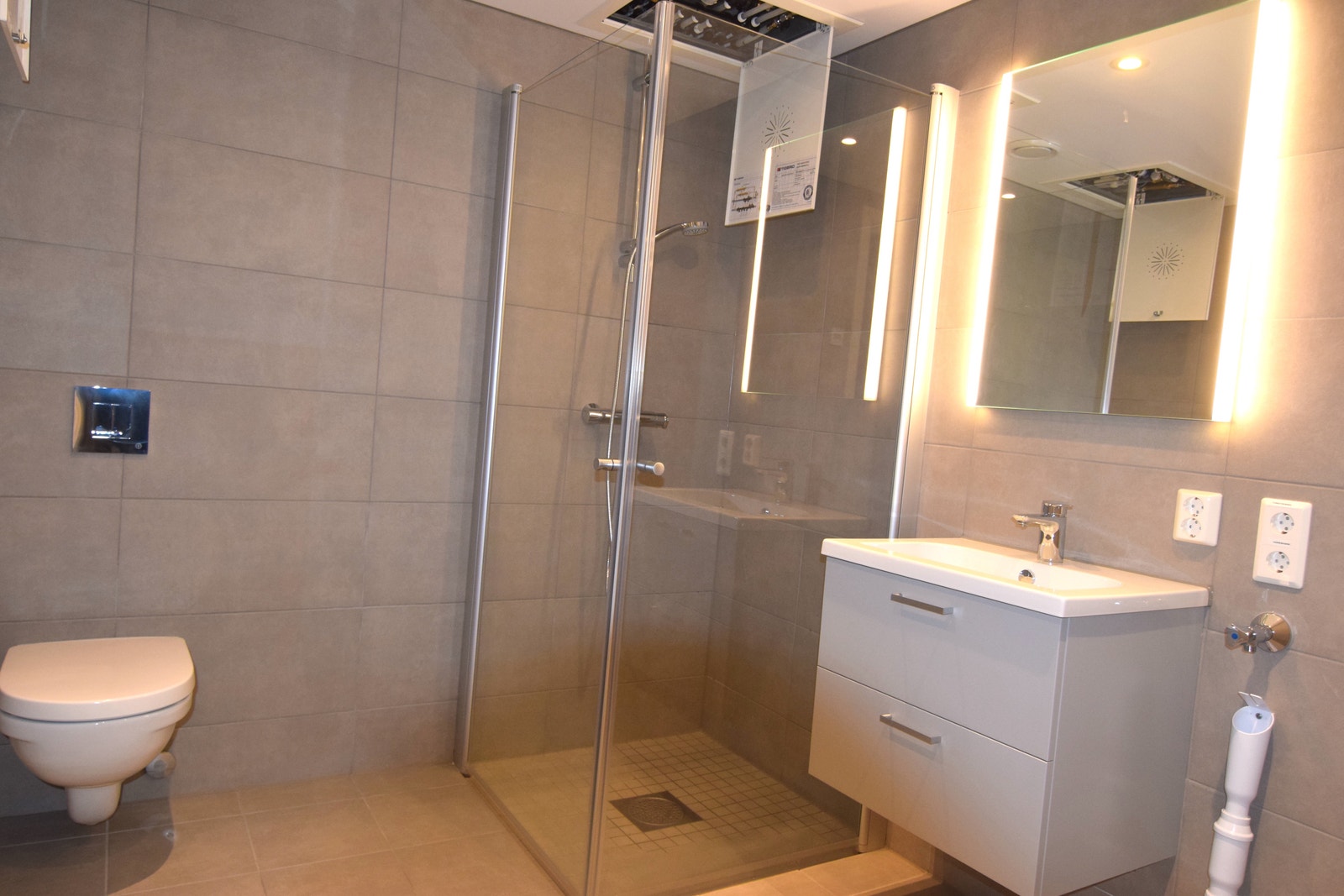 Bad med dusjhjørne og opplegg for vaskemaskin. Galleribilde