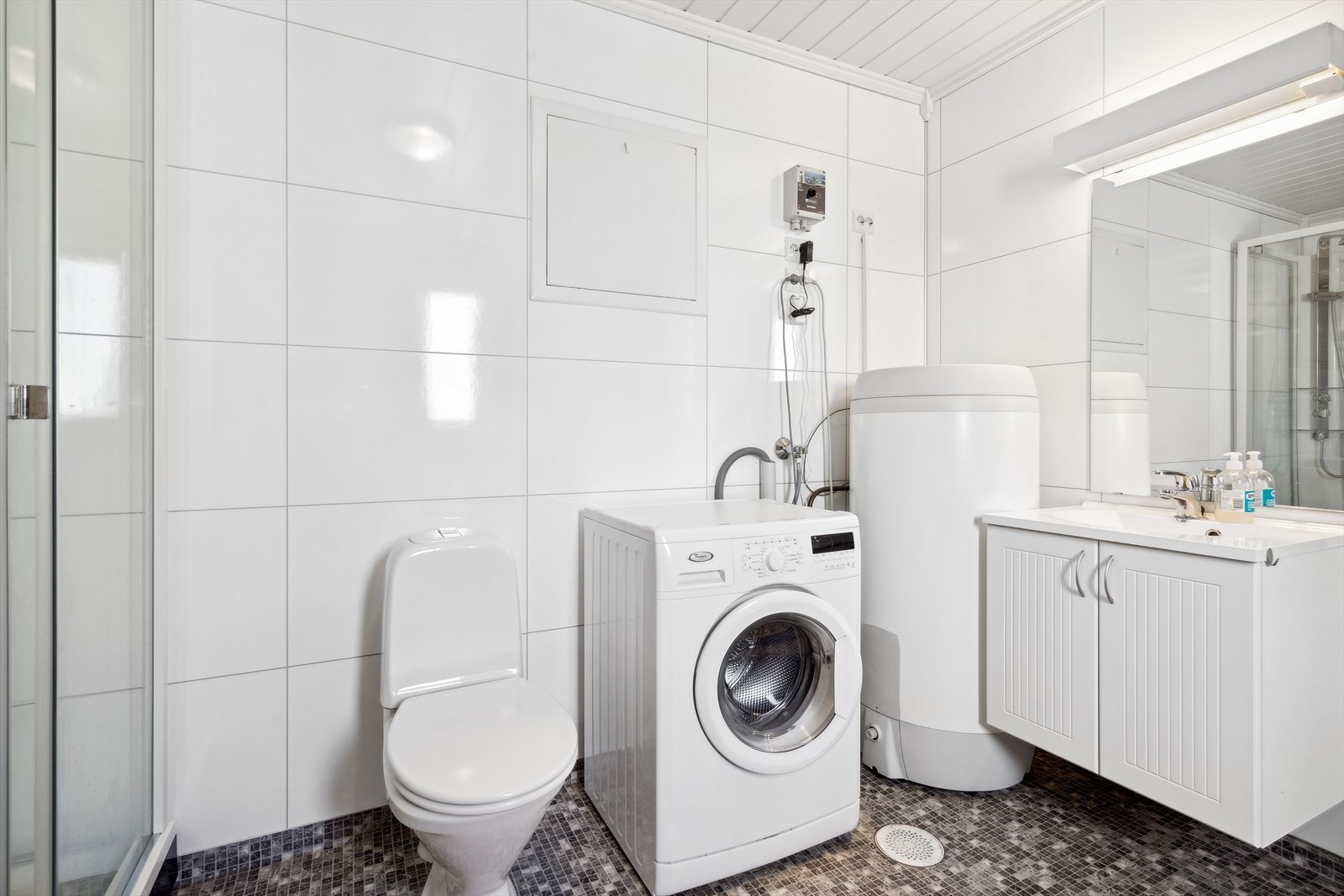 Baderommet er utstyrt med toalett, servant, dusj og har opplegg til vaskemaskin. Galleribilde