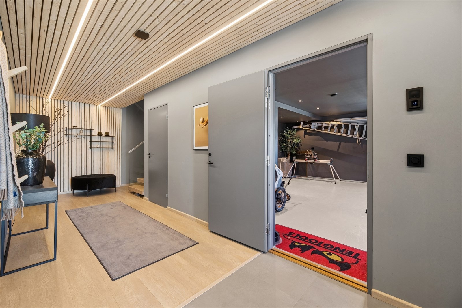 Fra gangen i første etasje kan du enten gå ut av boligen eller direkte inn i garasjen. Galleribilde