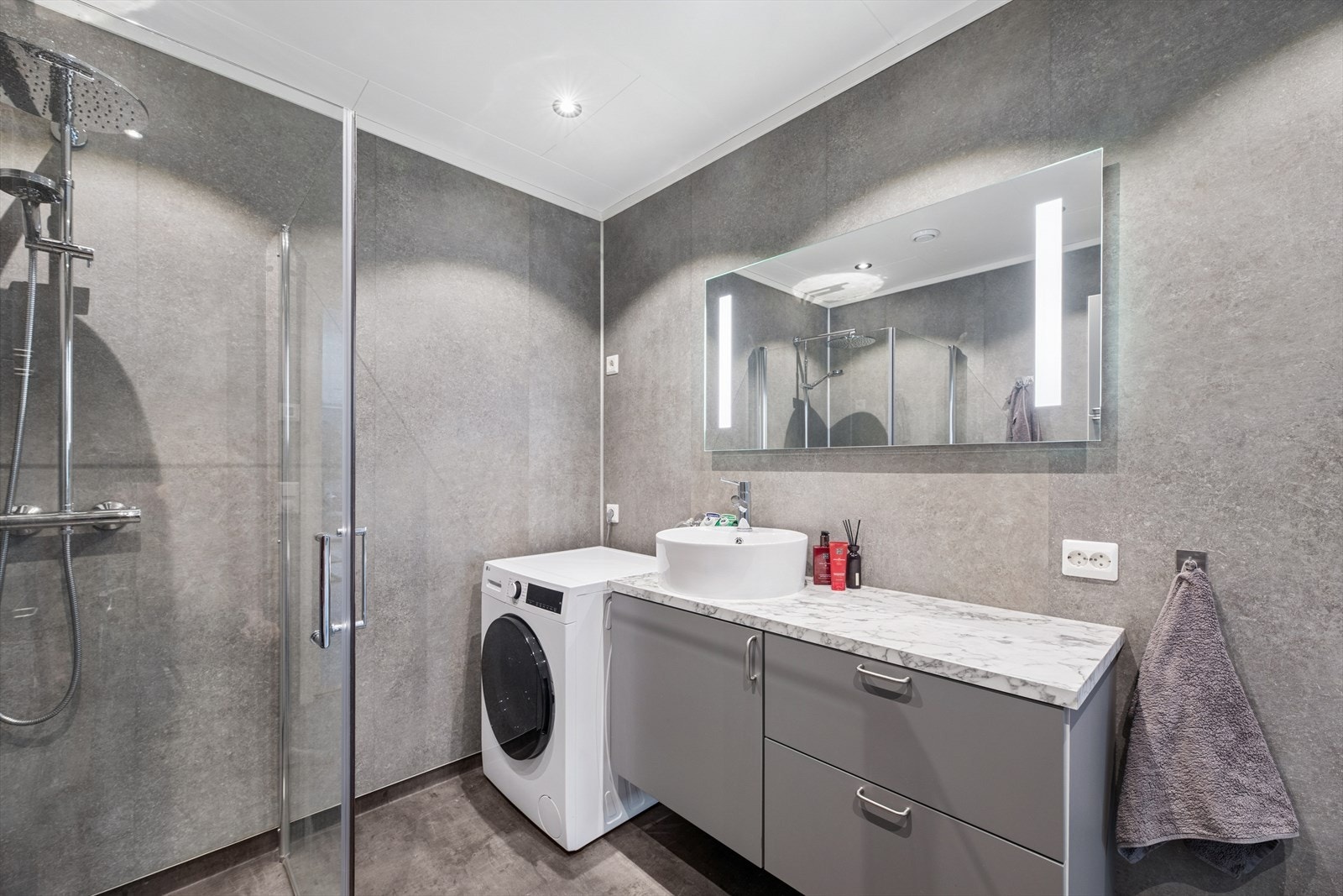 Bad med veggmontert toalett og dusjhjørne med tropisk dusj, skaper en spa-lignende opplevelse. Galleribilde