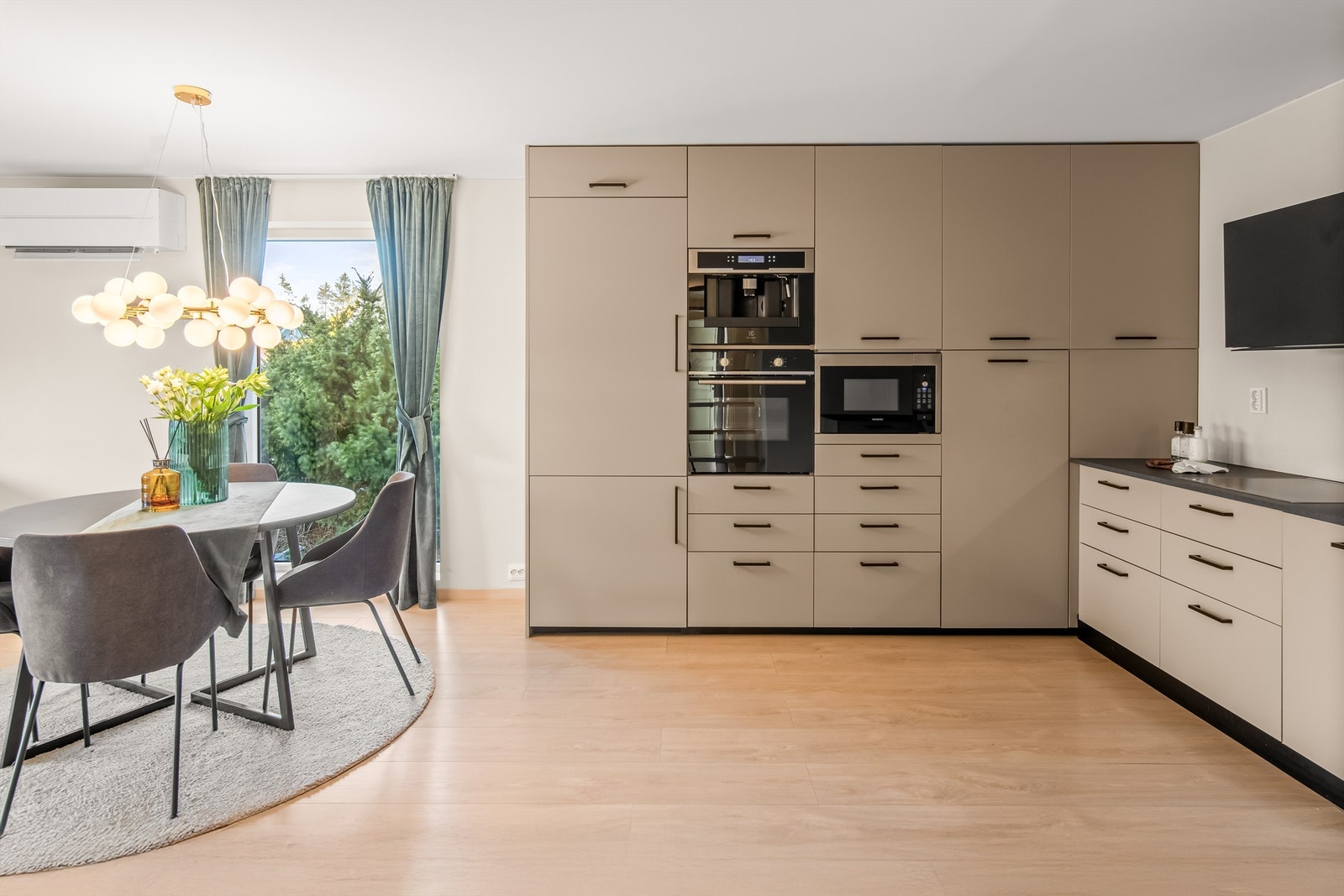 Kjøkkenet har slette fronter og godt med både skap og benkplass Galleribilde