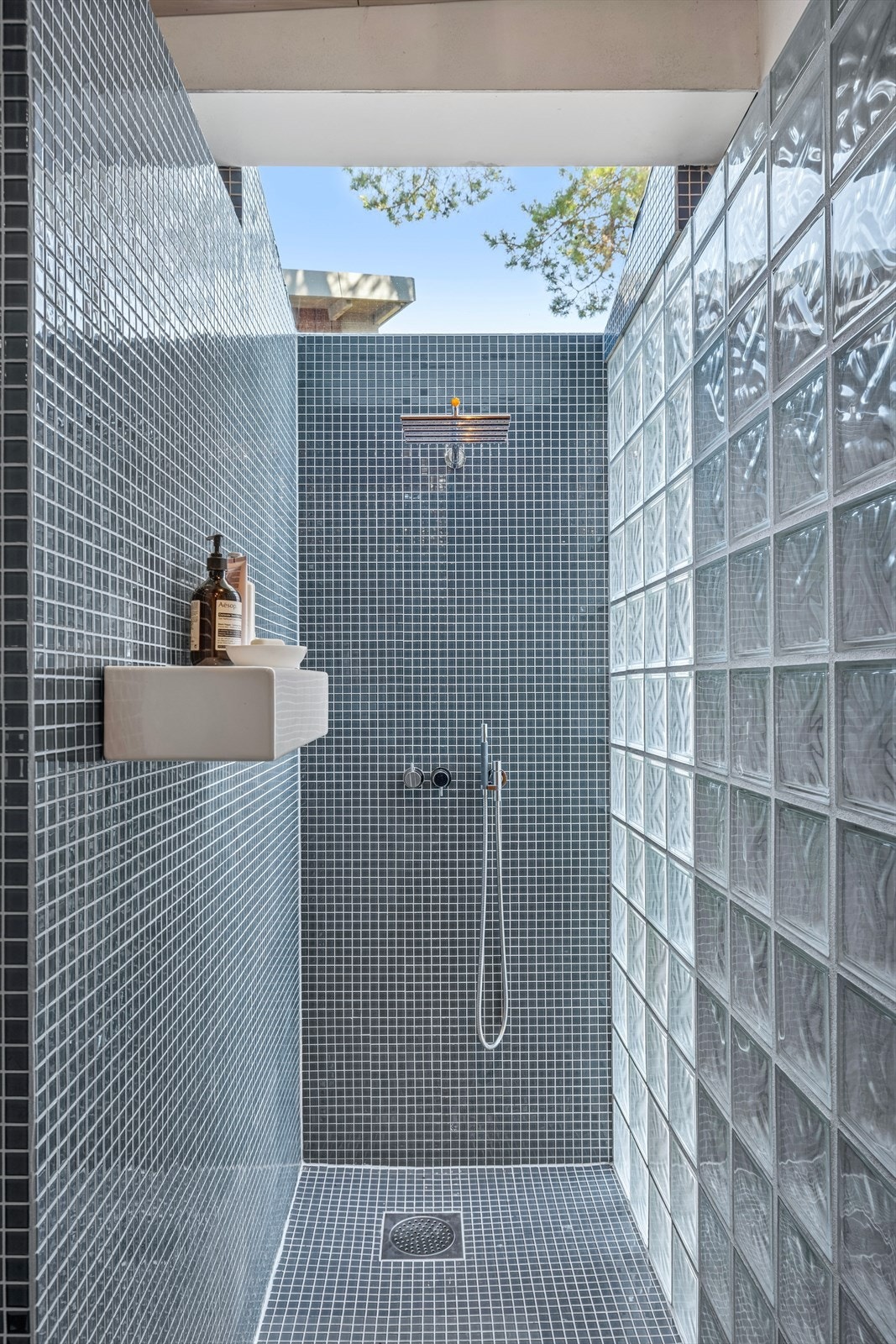 Dusjsonen er elegant avgrenset med glassbyggestensvegg samt glasstak og har mørk mosaikk som gir et eksklusivt uttrykk. Galleribilde