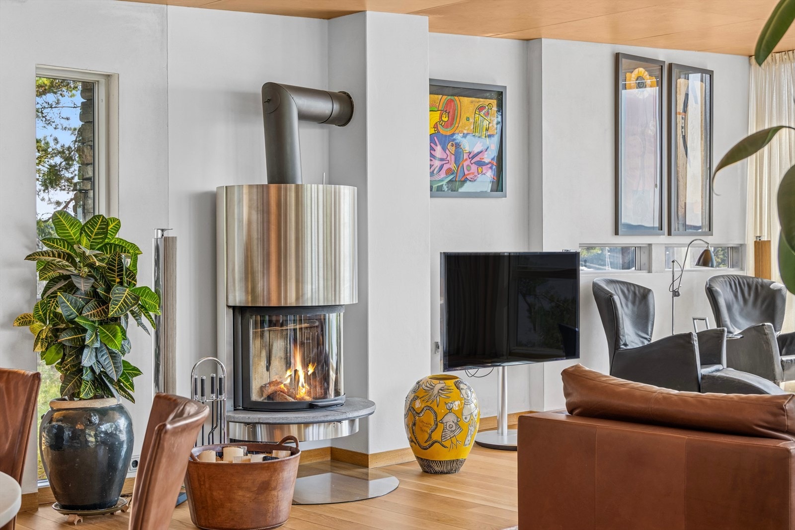 Moderne peisovn som utgjør et naturlig midtpunkt i rommet - både som varmekilde og stemningsskaper i den lune og innholdsrike stuen. Galleribilde