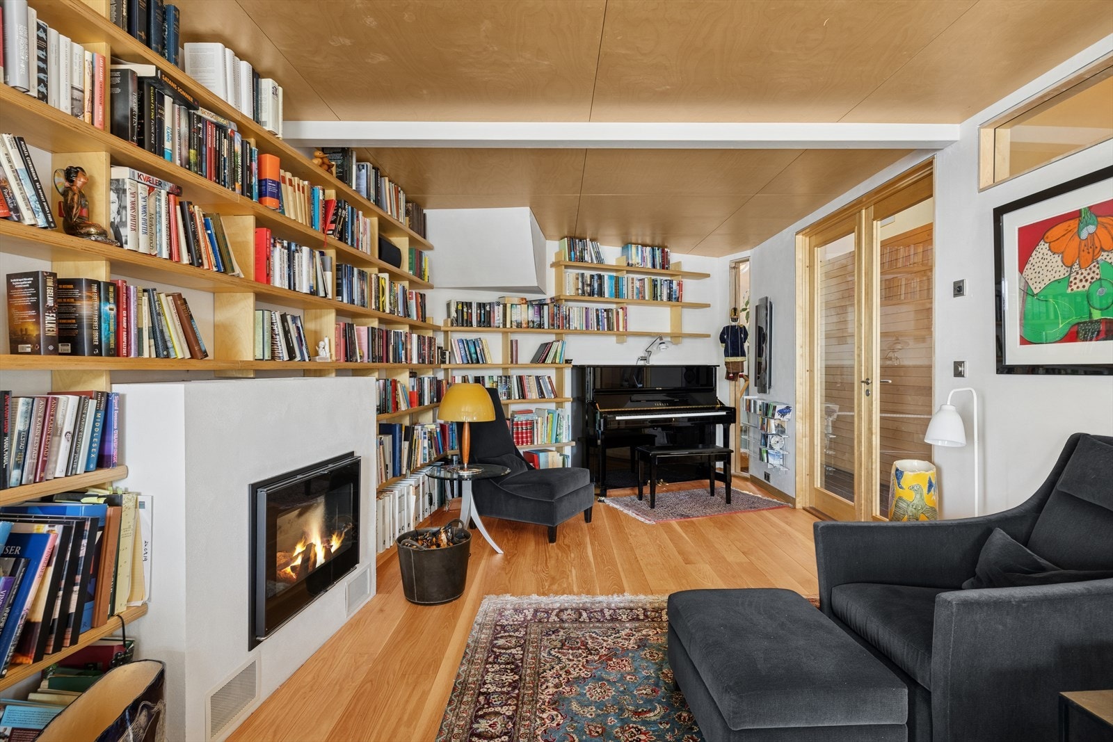 Lun og innholdsrik ekstra stue med peis, bibliotek og plass til både ro og inspirasjon - et perfekt rom for lesing, musikk og avslapning. Galleribilde