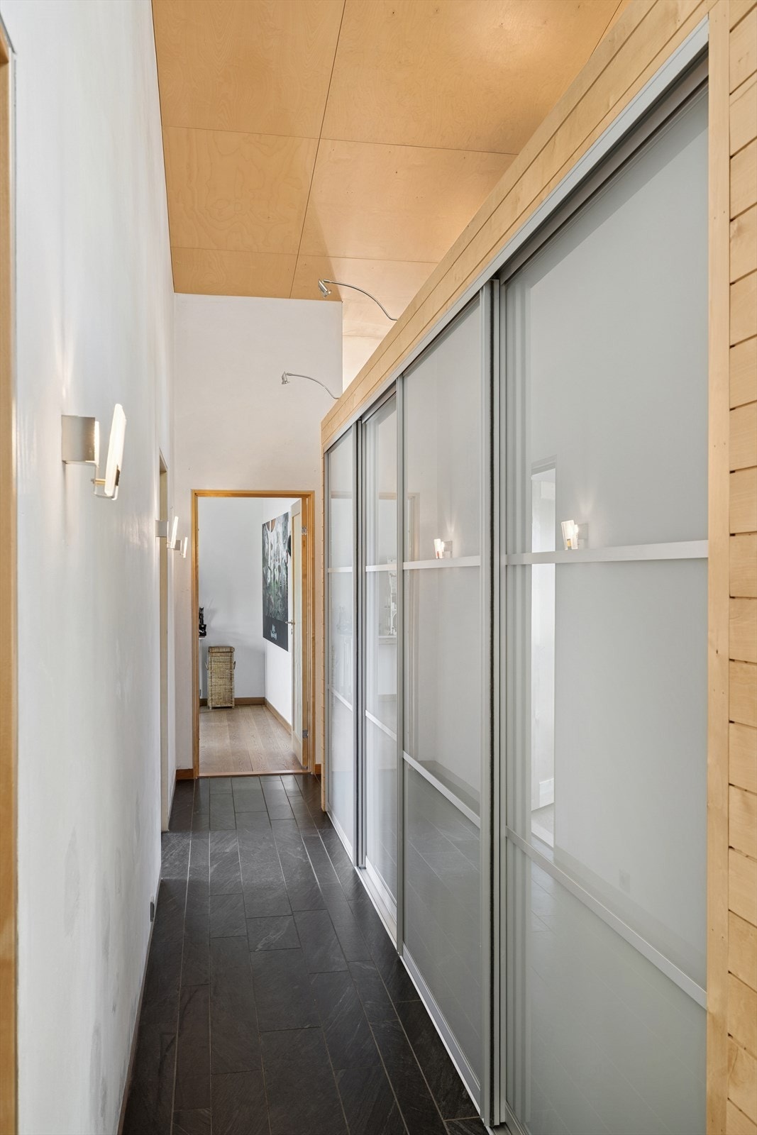 Lys og praktisk entré med skyvedørsgarderobe som effektivt deler opp gangen og gir adkomst til boligens soverom. Galleribilde