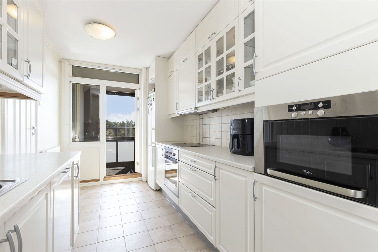 Kjøkken med lys innredning og god skap-og benkeplass Galleribilde