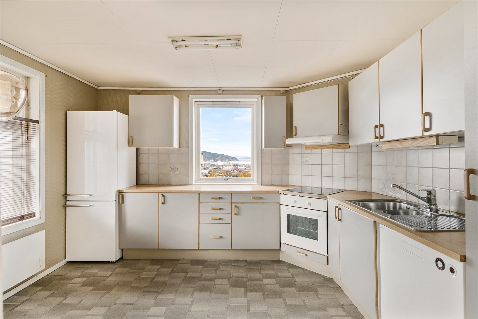 Romslig kjøkken på ca. 14 m². Kjøkkenet består av folierte skrog med slette fronter og laminert benkeplate. Galleribilde