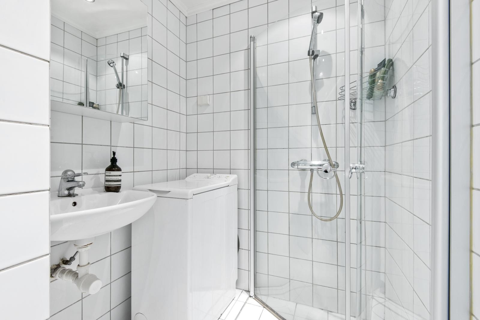 Baderom med vaskemaskin og vegghengt WC Galleribilde