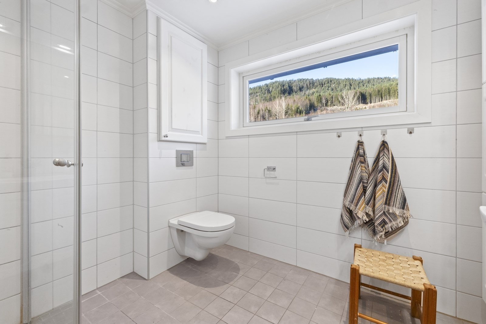 Dobbel servant med ett greps blandebatteri og vegghengt toalett. Innfellbare dusjdører. Galleribilde