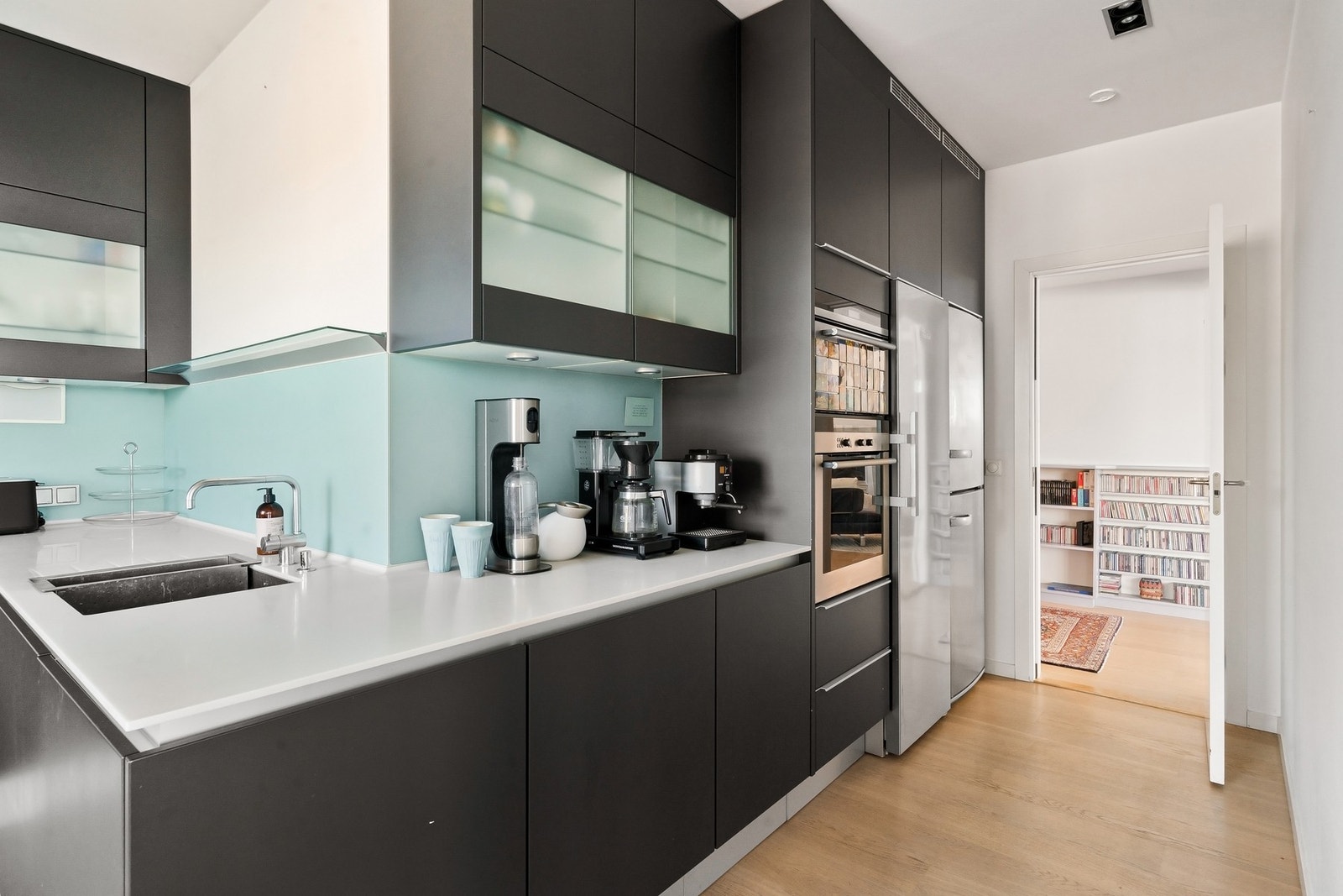 Integrert platetopp, kombi mikro/stekeovn, dampovn, oppvaskmaskin. Frittstående vinskap/fryseskap, kjøleskap. Galleribilde