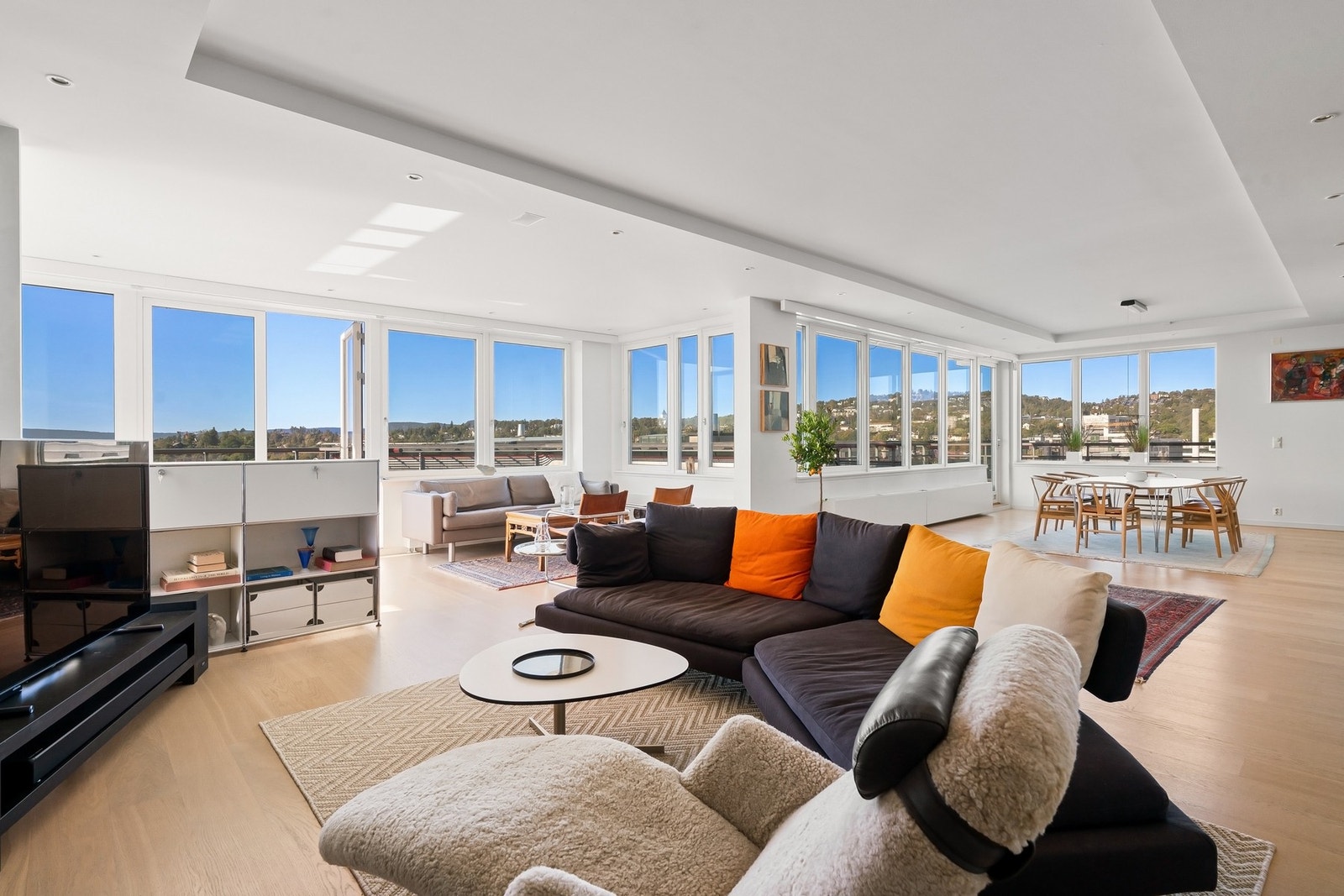 Åpent og luftig oppholdsrom med panoramautsikt og naturlig flyt mellom stue og spisestue. Galleribilde