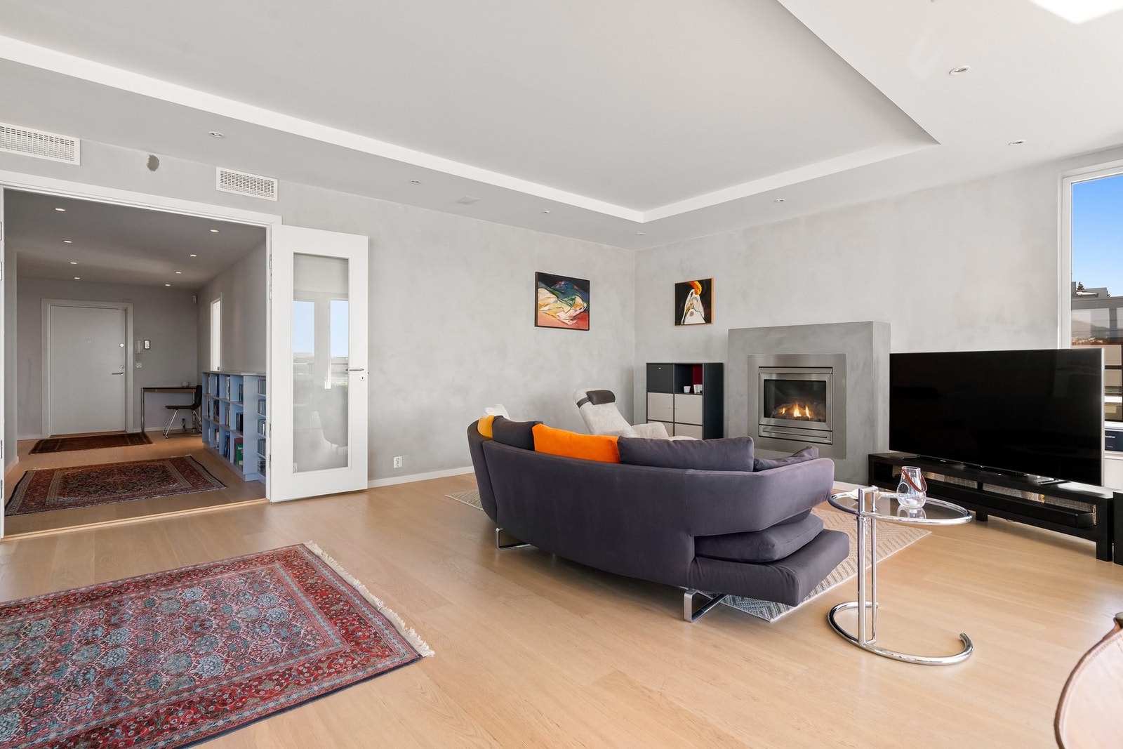 Stue med peis og lyse overflater. Galleribilde