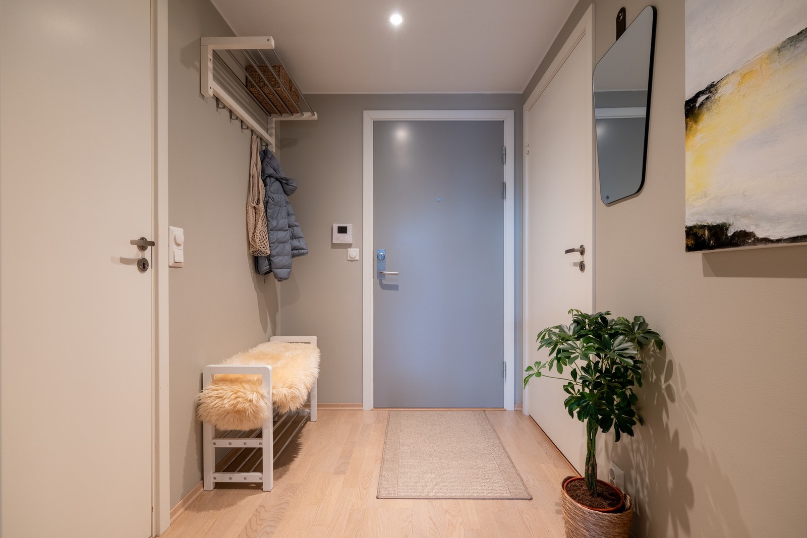 Her blir du møtt av en innbydende entré som gir et godt førsteinntrykk av leiligheten. Det er i tillegg god plass til blant annet knaggoppheng, speil og kommode. Galleribilde