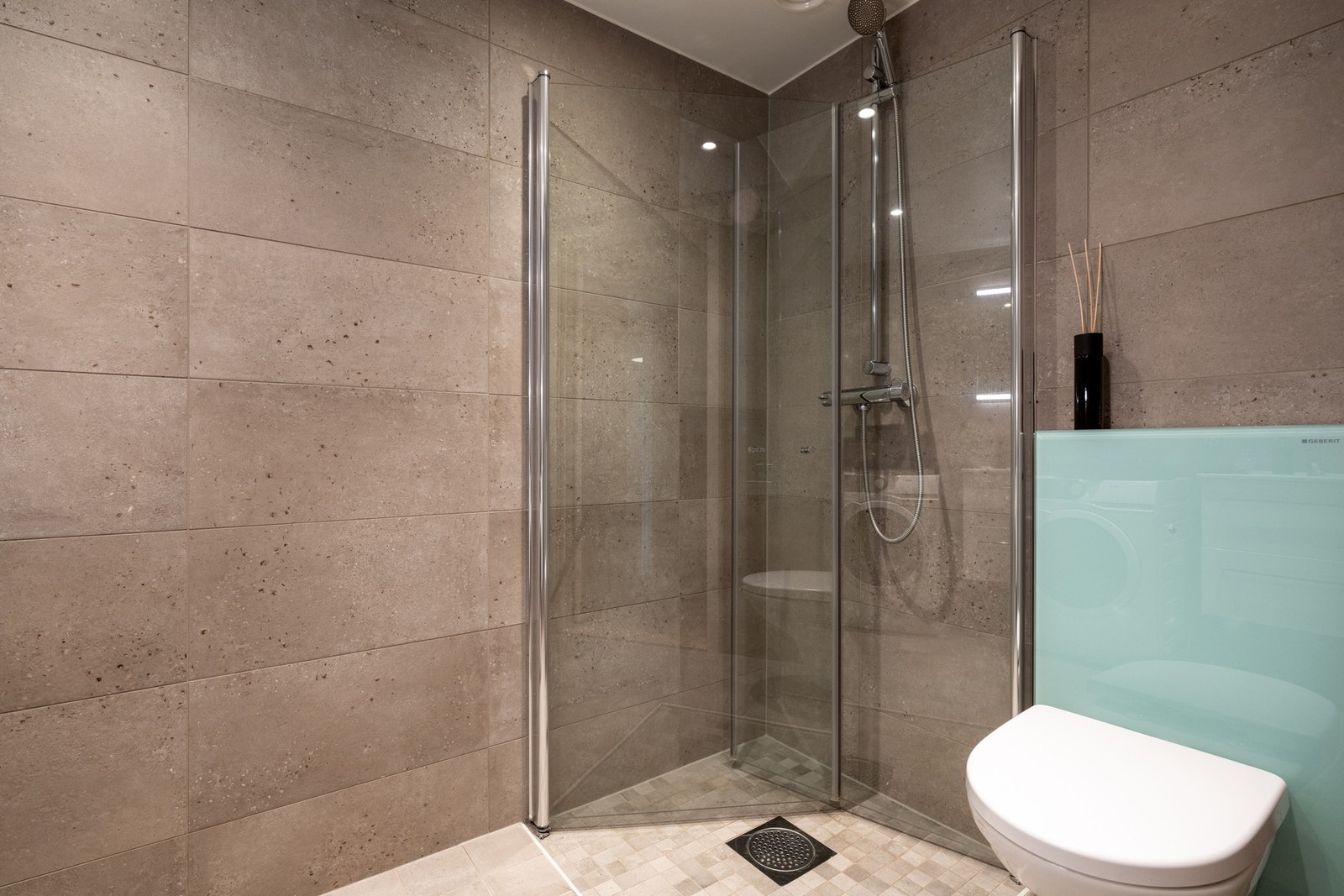 Videre er det vegghengt toalett og dusjhjørne med svingbare glassdører som frigjør plass på gulvet. Galleribilde