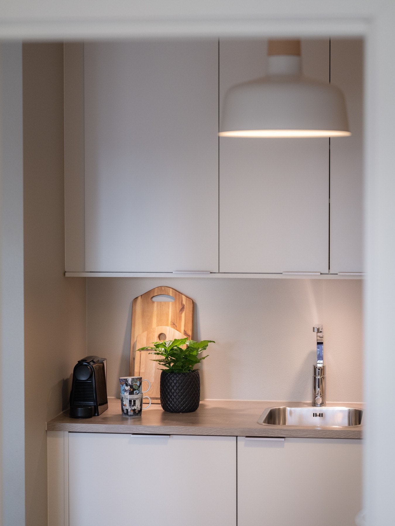 Kjøkkeninnredningen består av lyse, glatte fronter med benkeplate i laminat og nedfelt oppvaskkum i rustfritt stål med ett-greps armatur. Galleribilde