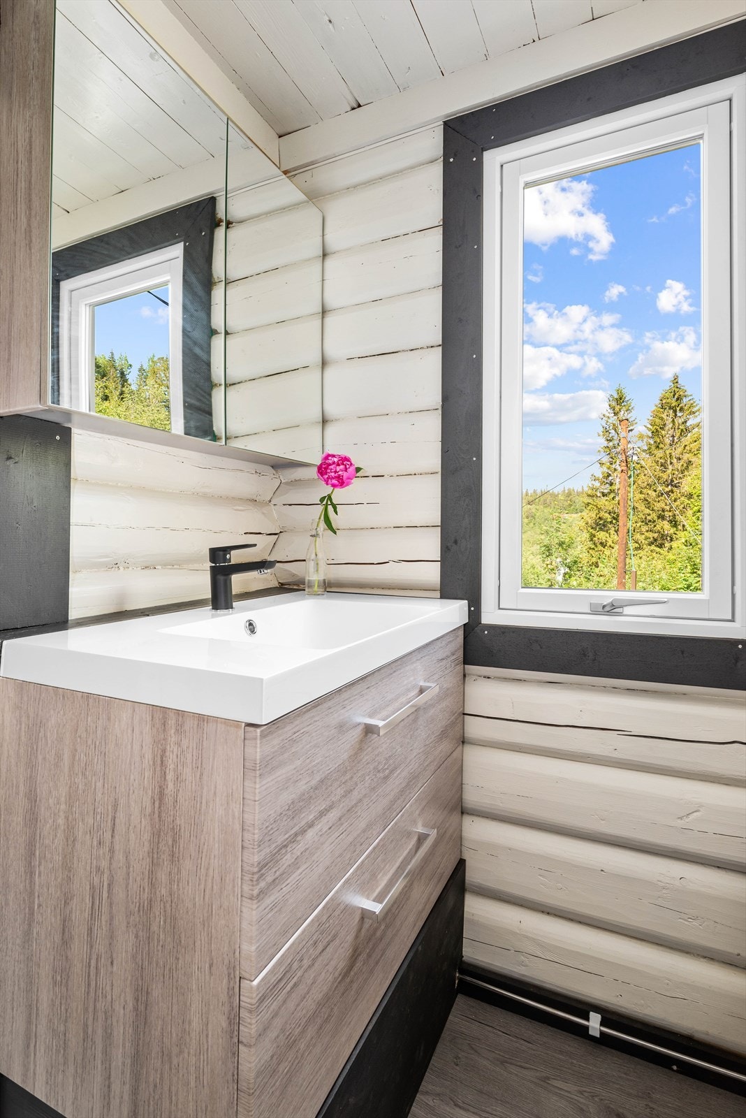 Badet har en stilren, Lind baderomsinnredning, pumpedusj og forbrenningstoalett. Galleribilde