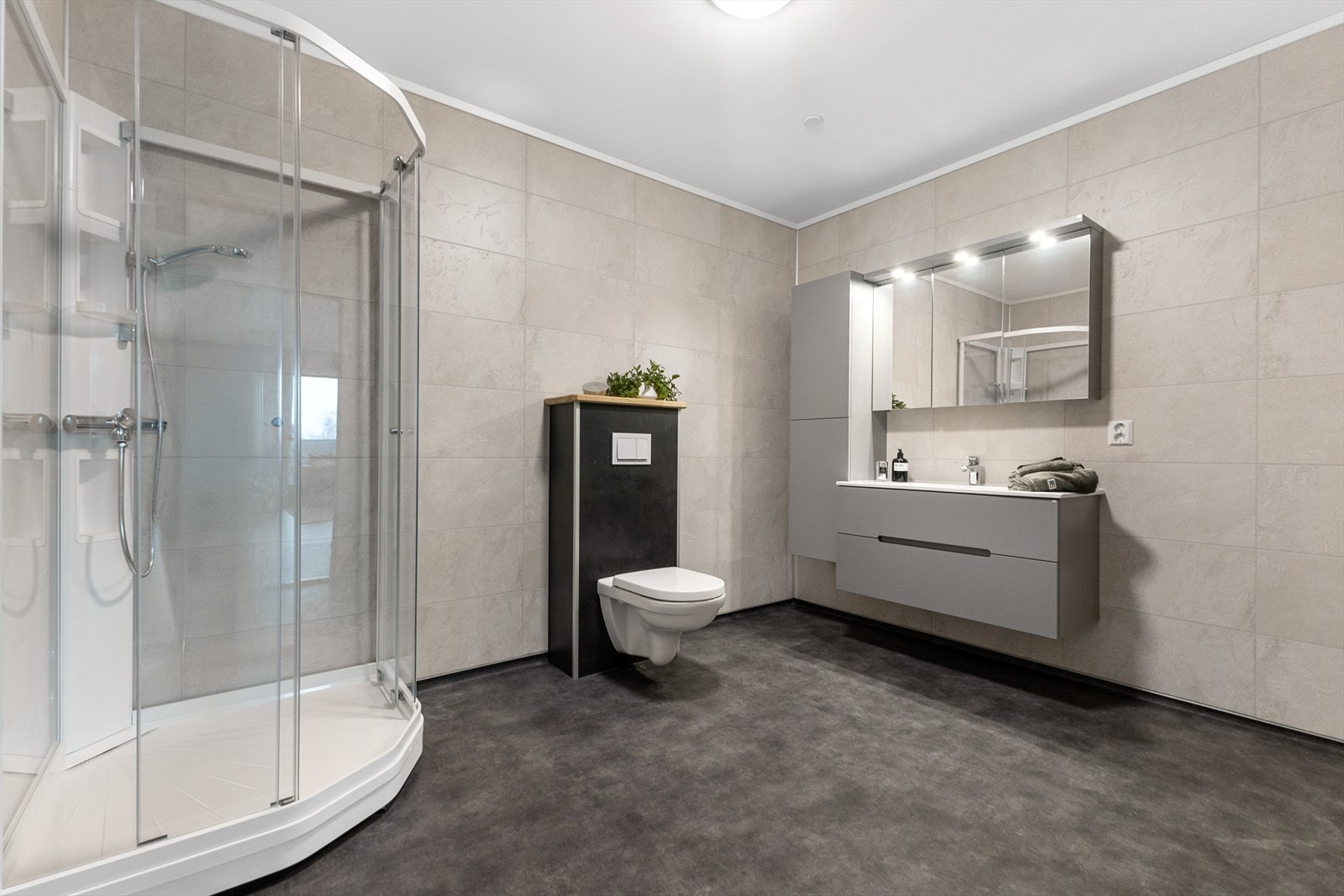 Stort dusjkabinett fra annerkjent leverandør. Vegghengt wc med trykkbetjening. Praktisk, pen baderomsinnredning med både store skuffer, speilskap og sideskap. Galleribilde